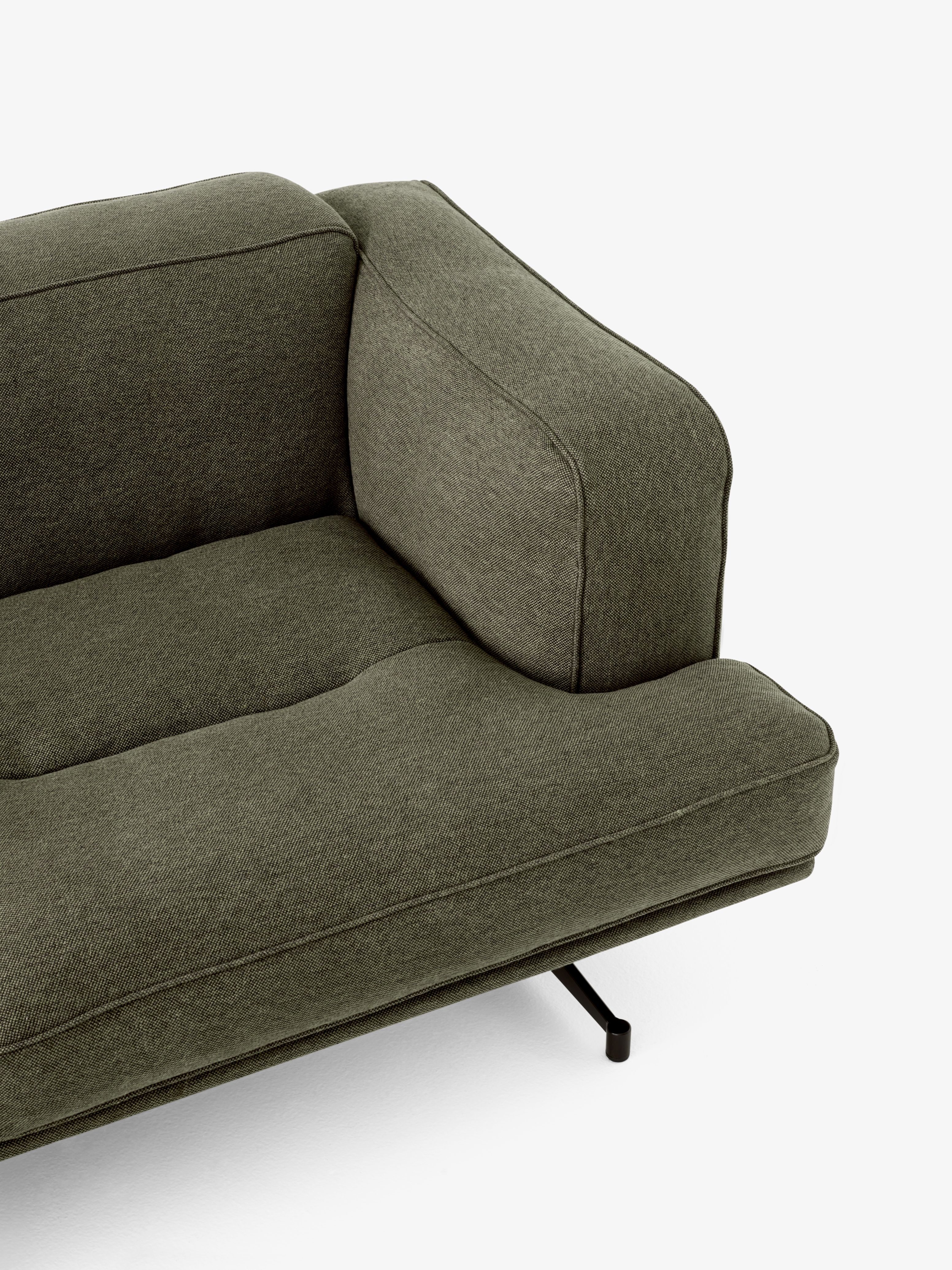 Detailaufnahme des Inland AV22 Sofas von AndTradition in Olivgrün mit minimalistischem Design und schwarzen Metallfüßen.