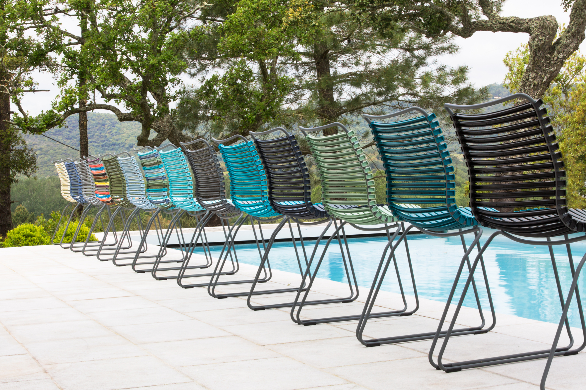Reihe von Houe Click Dining Stühlen ohne Armlehne in Multicolor am Pool. Outdoor Möbel.