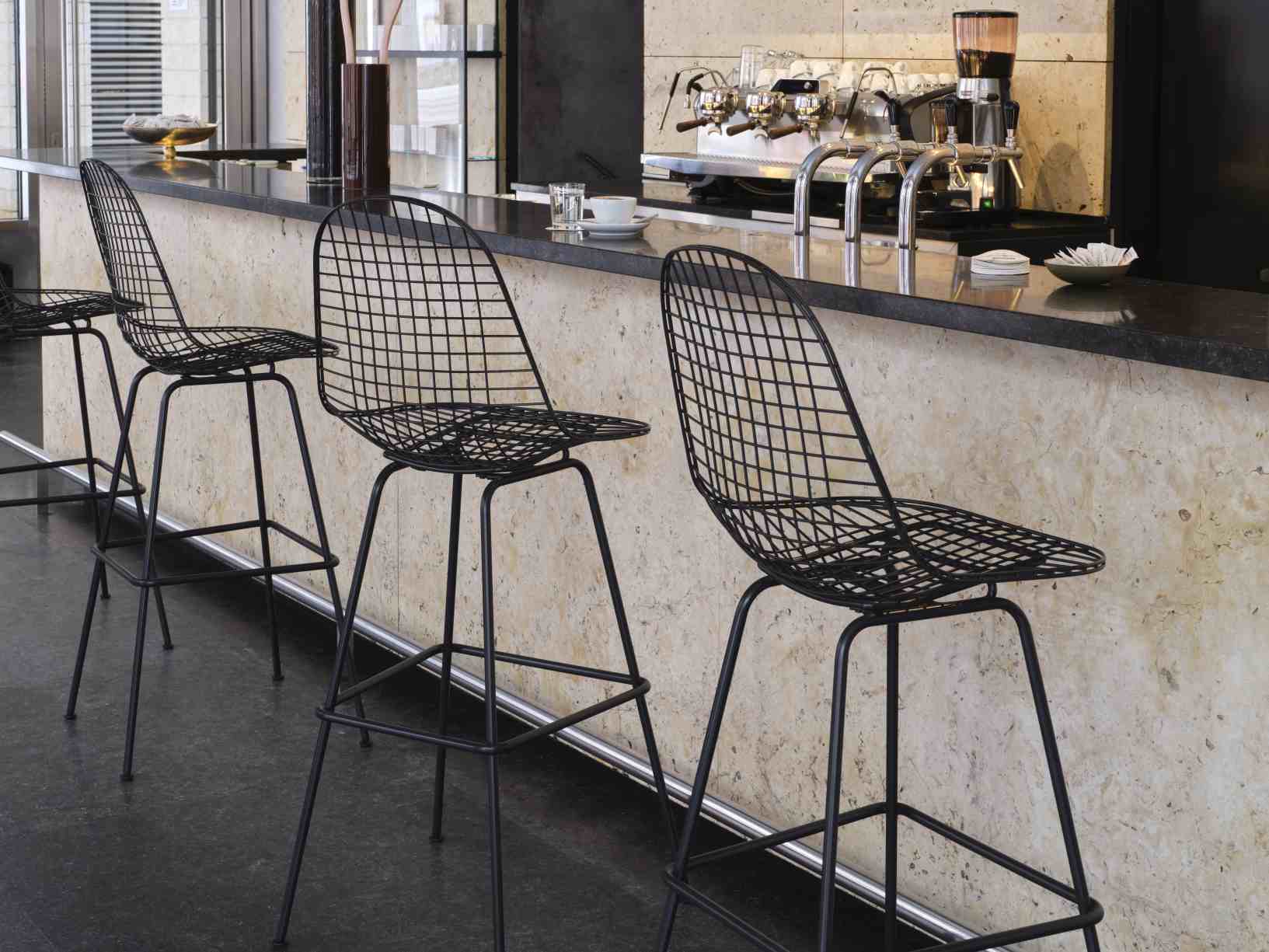 Eames Wire Bar Stool von Vitra, schwarze Barhocker aus Drahtgeflecht an einer Bar.