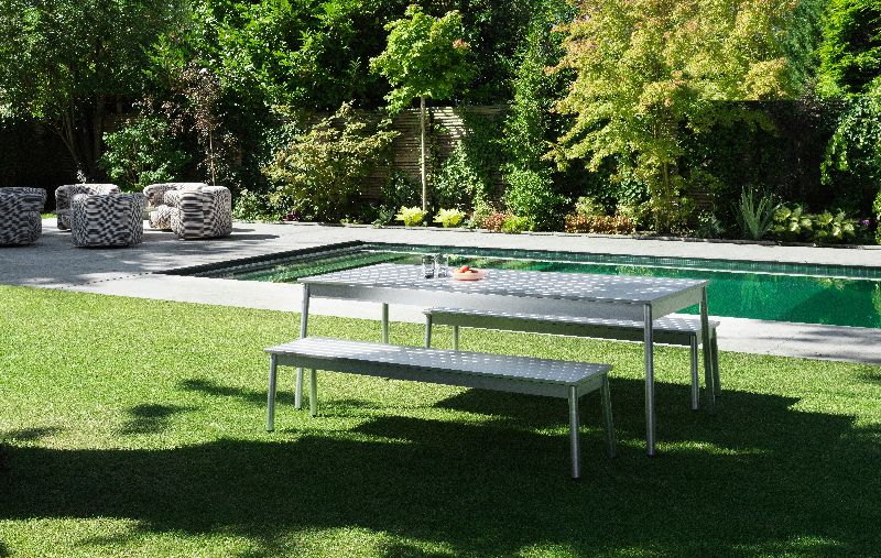 Normann Copenhagen Ex Bank Outdoor auf Rasen vor Pool, moderne Gartenmöbel für Terrasse und Garten.