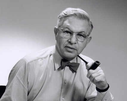 Schwarz-Weiß-Foto eines Mannes mit Brille, Fliege und Pfeife. Klassischer Stil, Retro-Look.