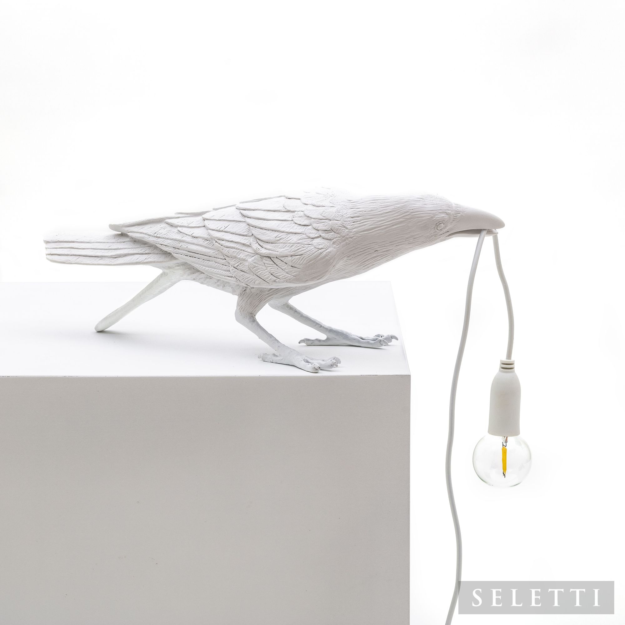 Weiße Bird Lamp Playing Leuchte von Seletti: Dekorative Tischleuchte in Form eines Raben mit Glühbirne im Schnabel.