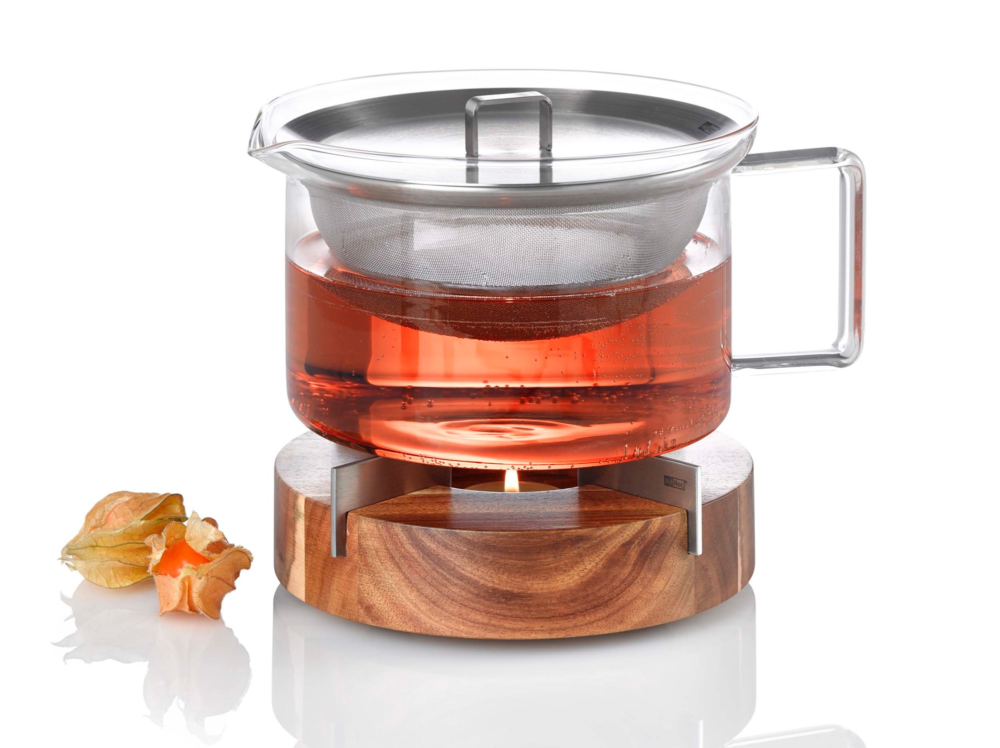 AdHoc Stövchen: Teekanne aus Glas mit Teesieb auf Holz-Speisenwärmer mit Teelicht.