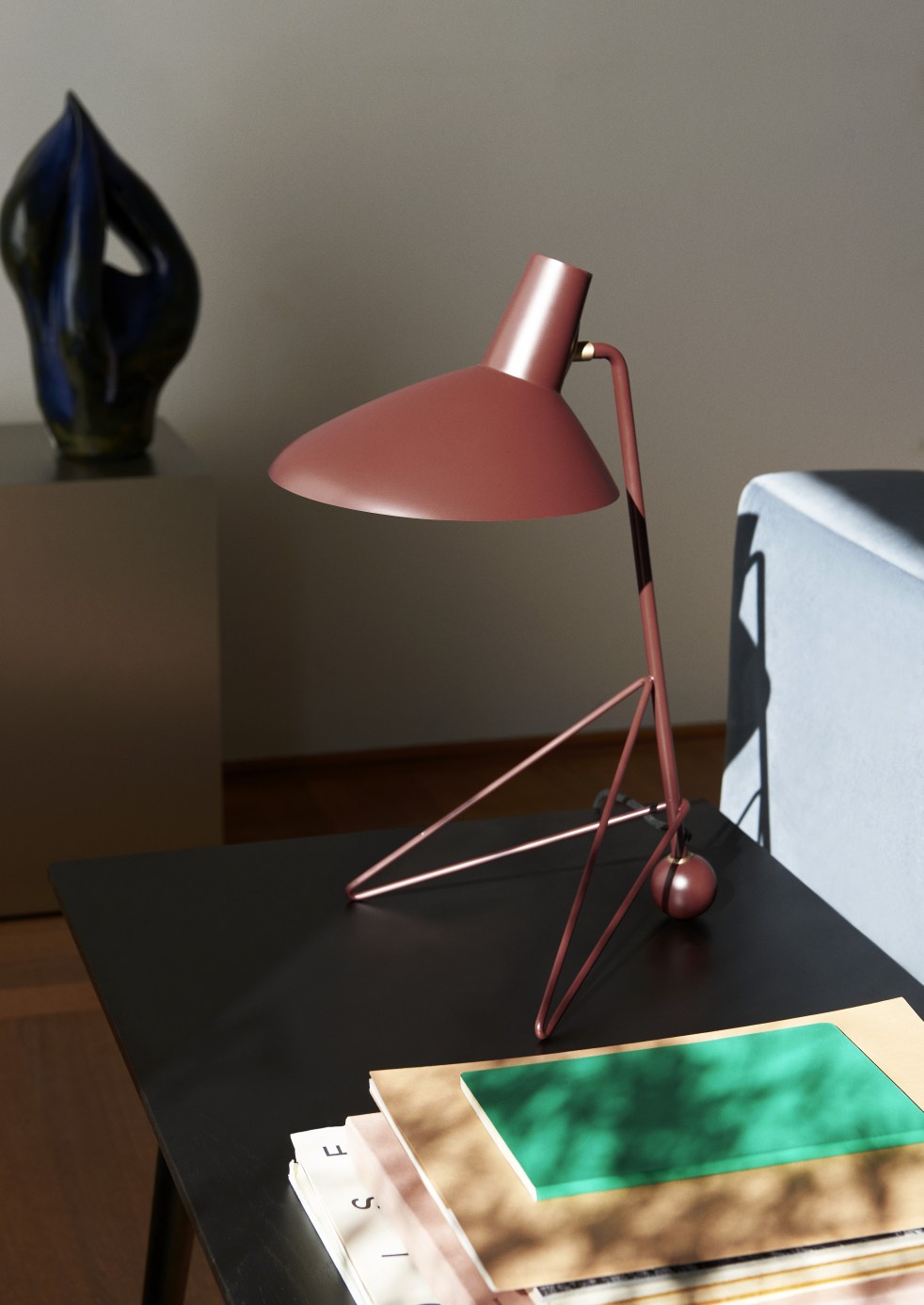 AndTradition In Between Table SK23 Couchtisch aus Holz, schwarz, mit Lampe und Dekoration.