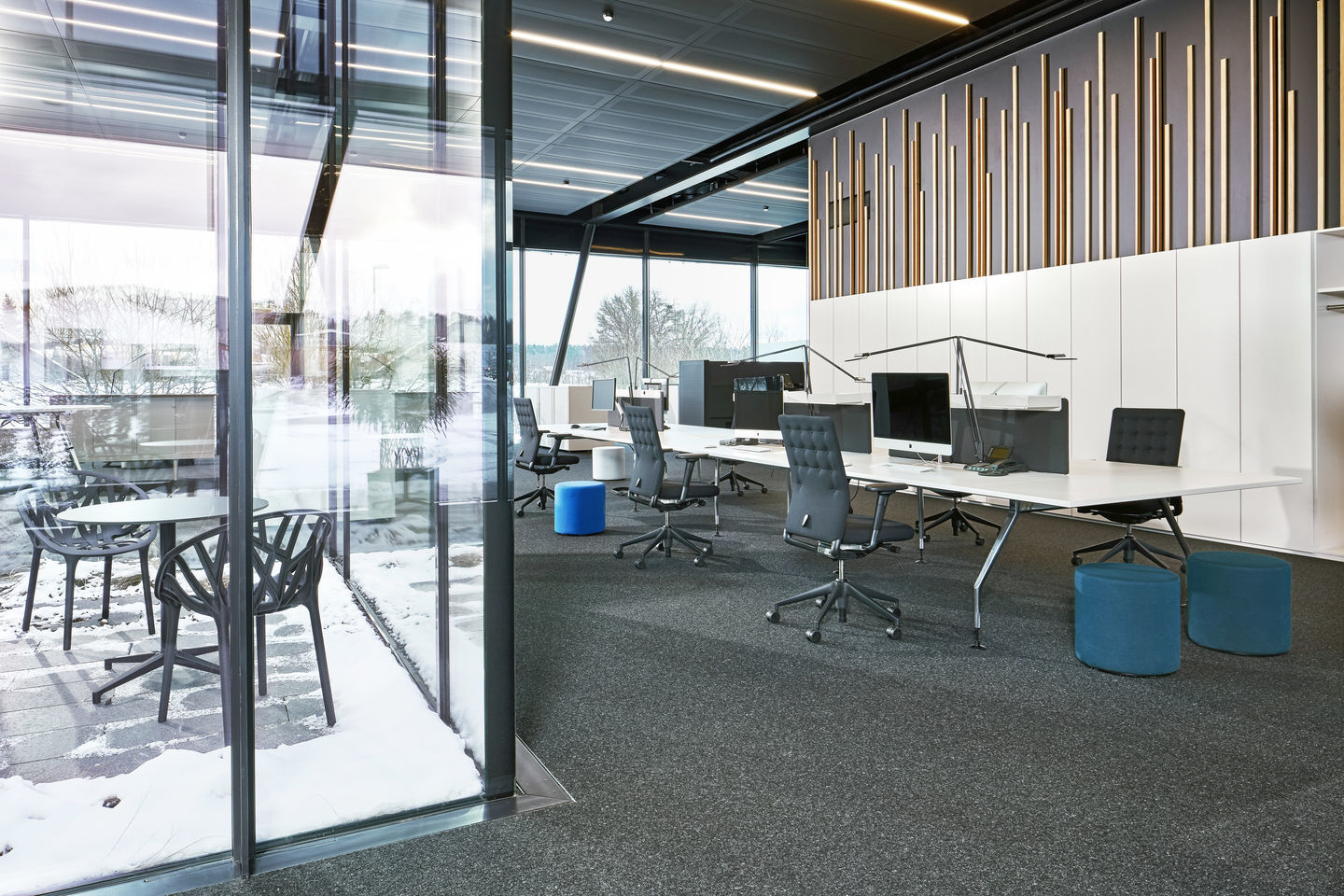 Helles modernes Büro mit mehreren Vitra ID Chair Bürodrehstühlen und weißen Schreibtischen unter linearen Deckenleuchten.