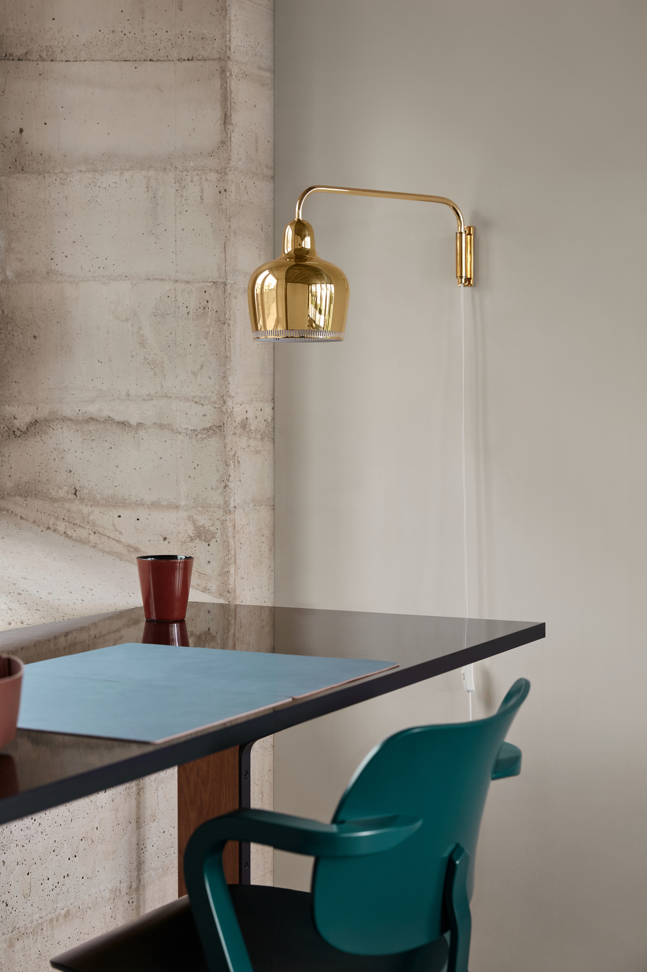 Nahaufnahme des Artek Aslak Chair Stuhls in Grün, kombiniert mit modernem Schreibtisch und goldener Lampe.