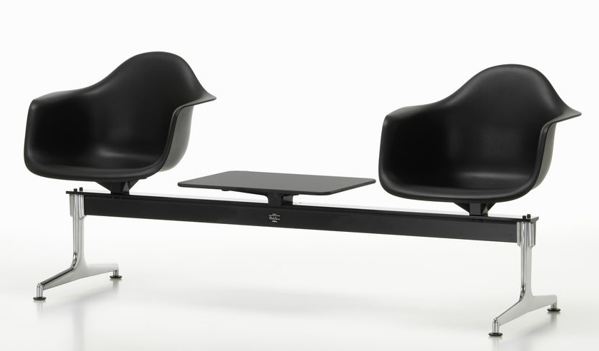 Schwarze Eames Plastic Armchairs auf Traverse von Vitra mit Ablagetisch, modernes Wartezimmer-Design.