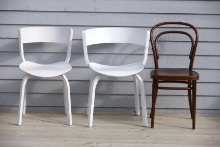 Drei Stühle: Zwei weiße und ein brauner 214 M Bugholzstuhl im Thonet-Stil.