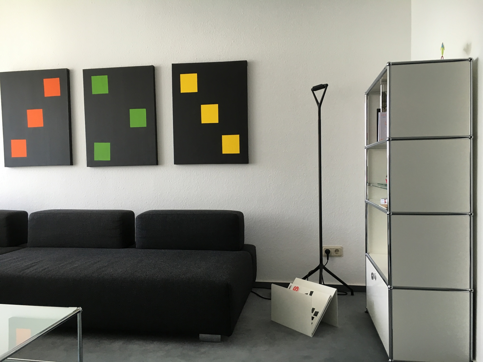 Moderner Wohnraum mit ZS01 L Zeitungsständer Stadie aus Edelstahl, neben Sofa und Regal für stilvolle Aufbewahrung.