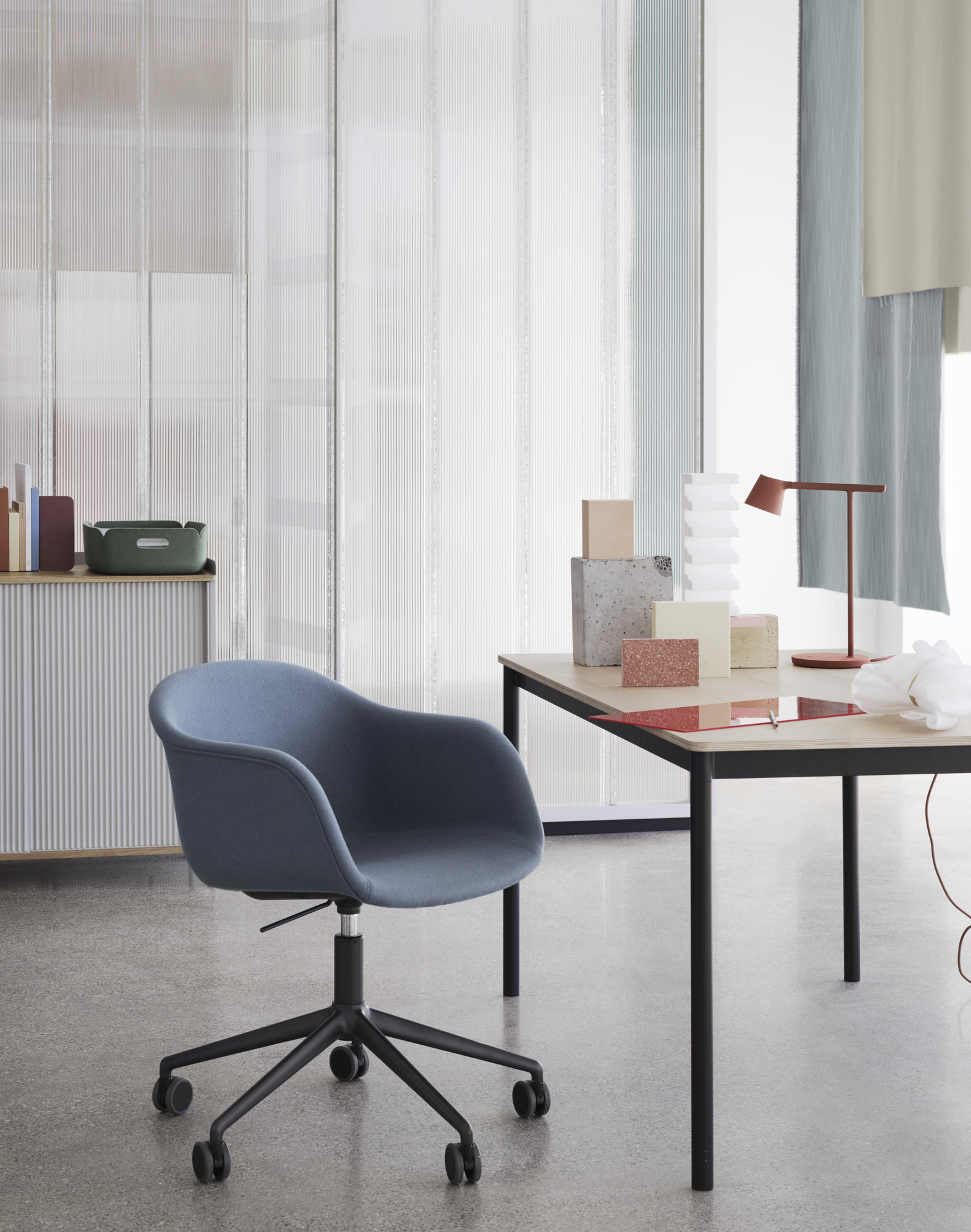 Blauer Fiber Armchair von Muuto mit Drehfuß und Polsterung im modernen Büro.