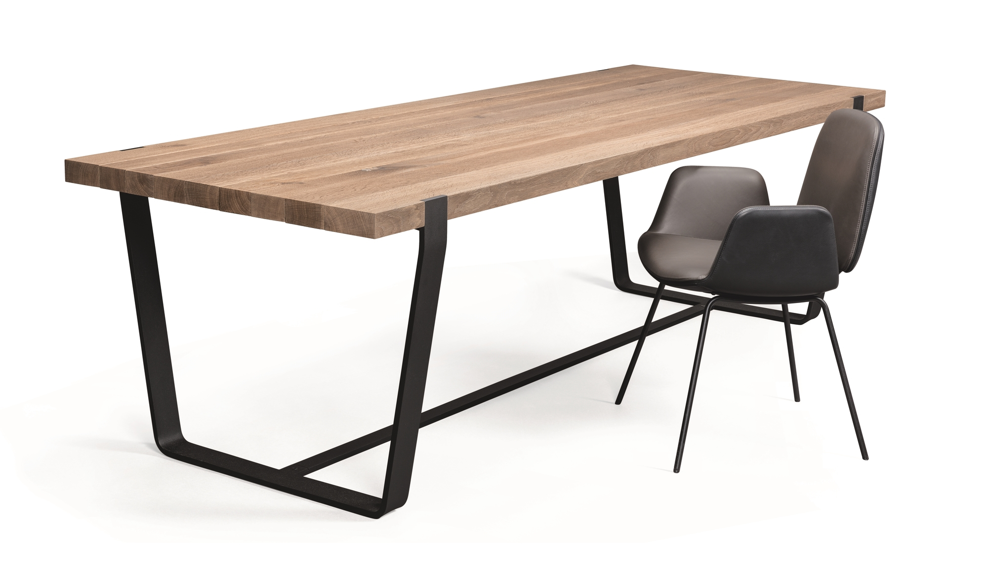 BB 11 Clamp Tisch von Janua mit Eichenplatte und schwarzen Metallbeinen neben zwei Stühlen.