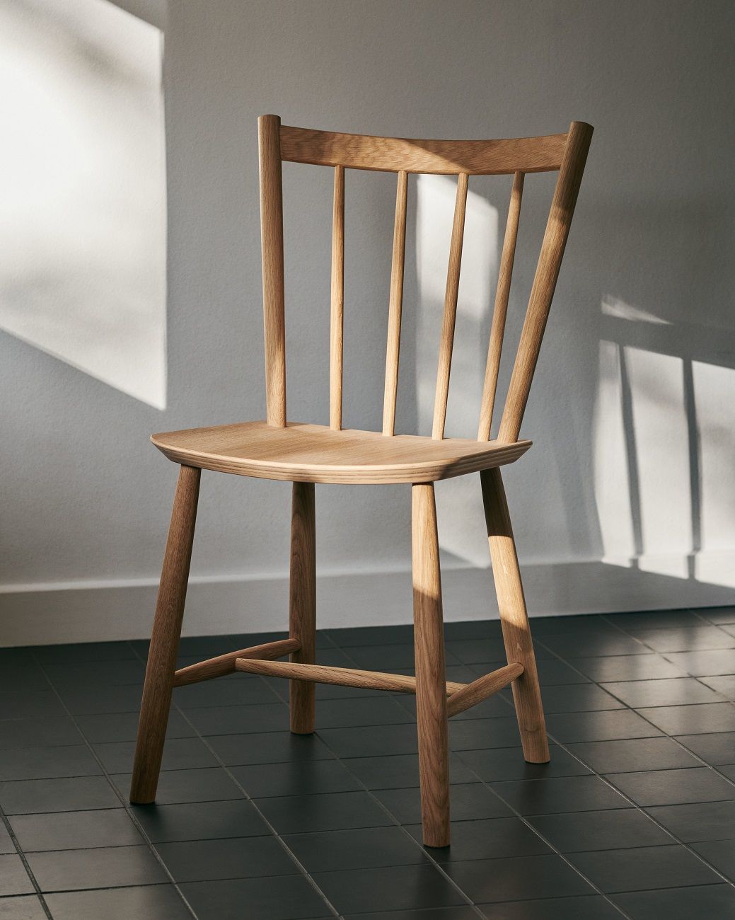J41 Stuhl von Hay, ein klassischer Holzstuhl mit Sprossenlehne und hellem Holzton.