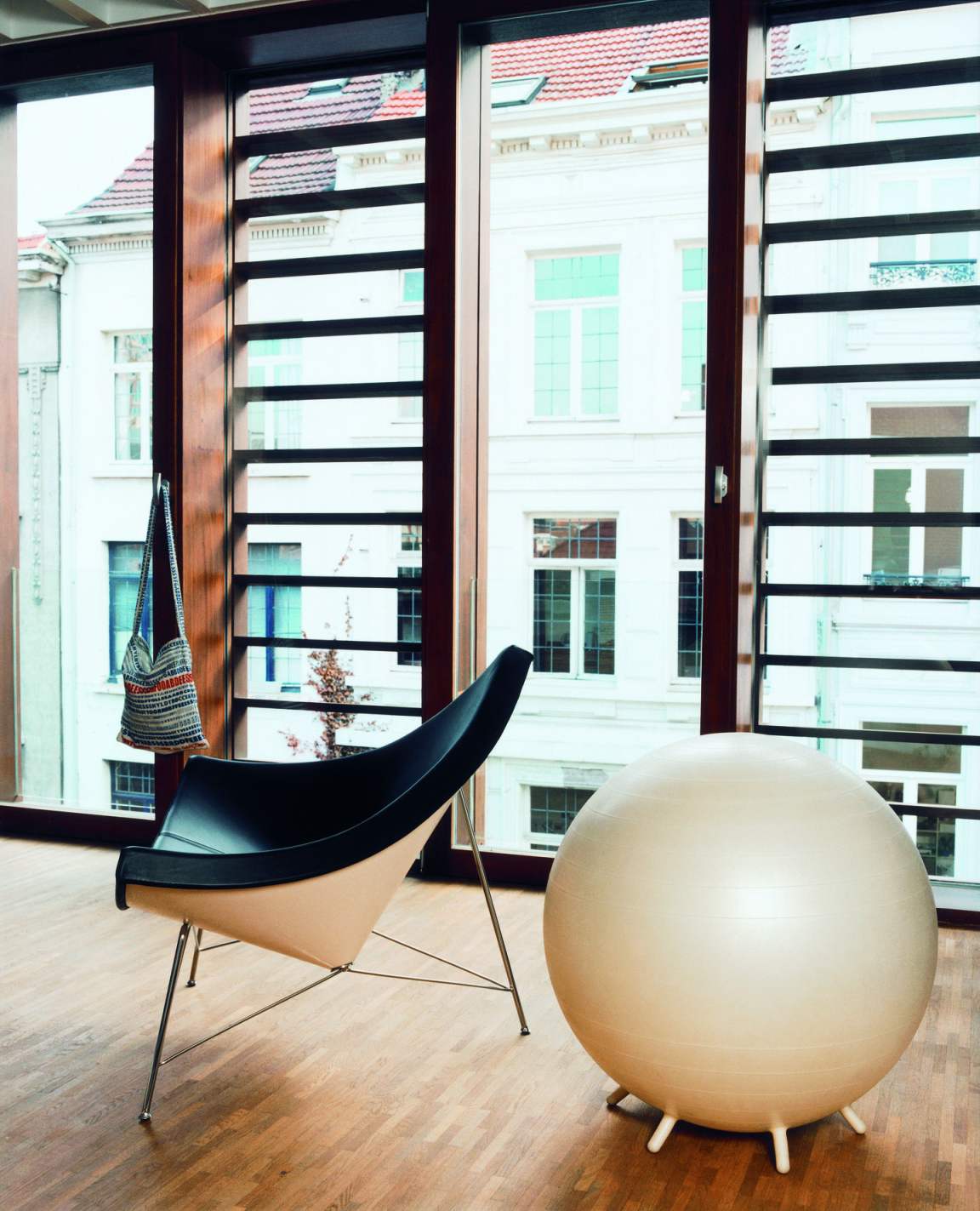 Vitra Coconut Chair in Schwarz und Beige mit passendem Gymnastikball vor Fenster.