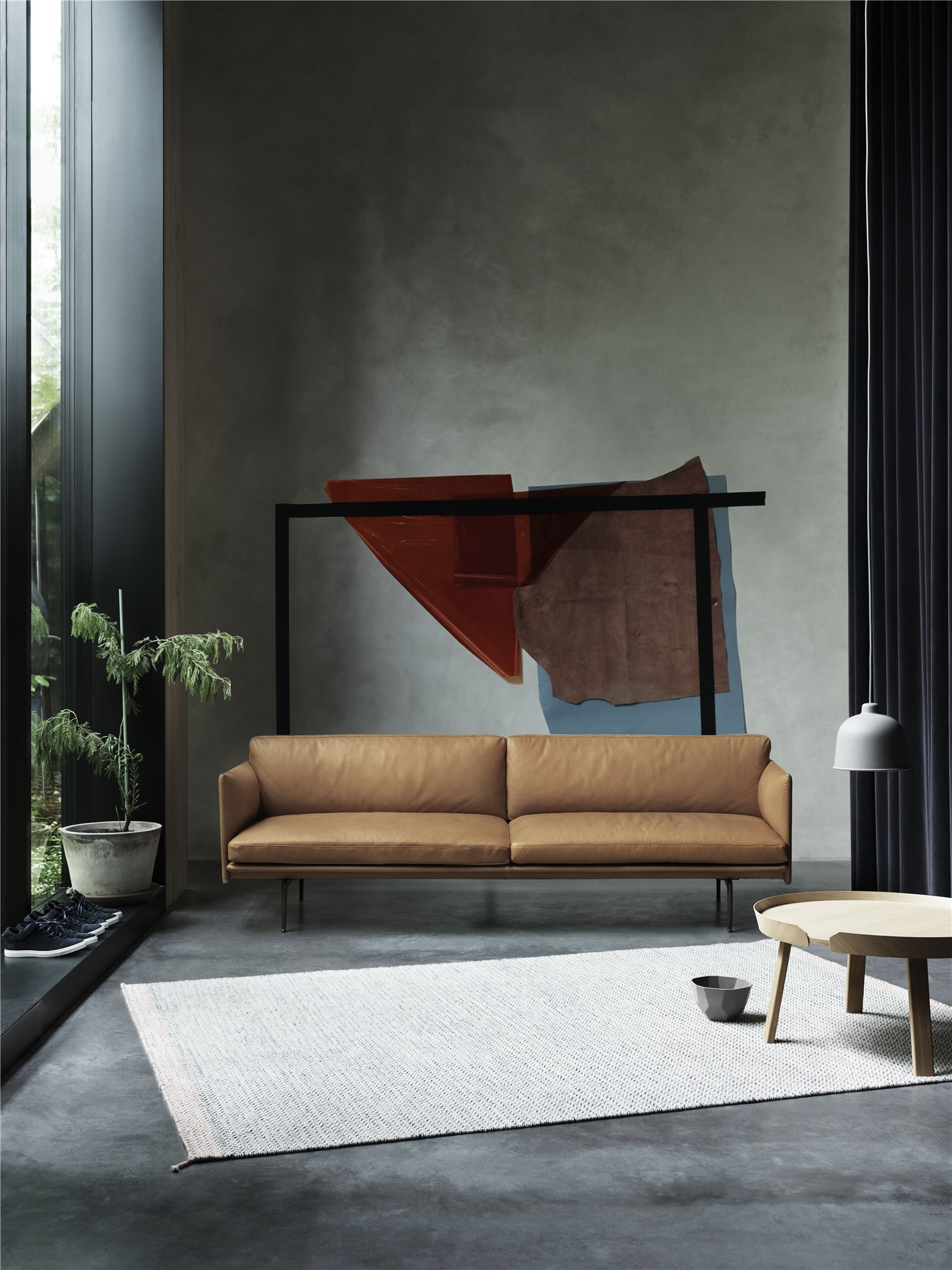 Modernes Wohnzimmer mit braunem Ledersofa, hellem Teppich und abstraktem Kunstwerk an der Wand.