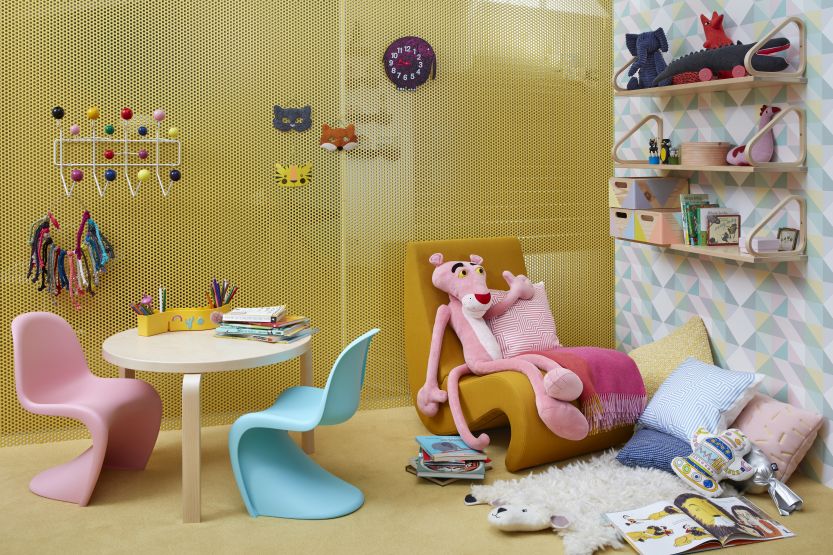 Kinderzimmer mit Eames Hang it all Garderobe, Tisch, Stühlen und Spielsachen für eine farbenfrohe Einrichtung.