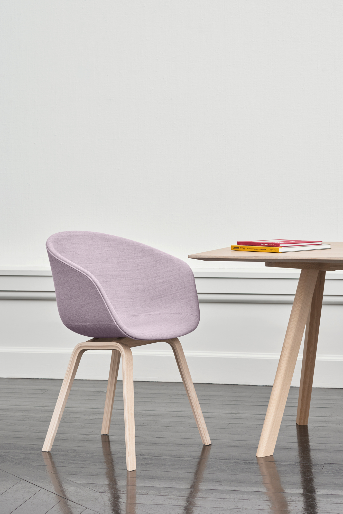 About A Chair AAC23 Stuhl von Hay mit lila Polsterung und hellem Holzgestell neben Holztisch.