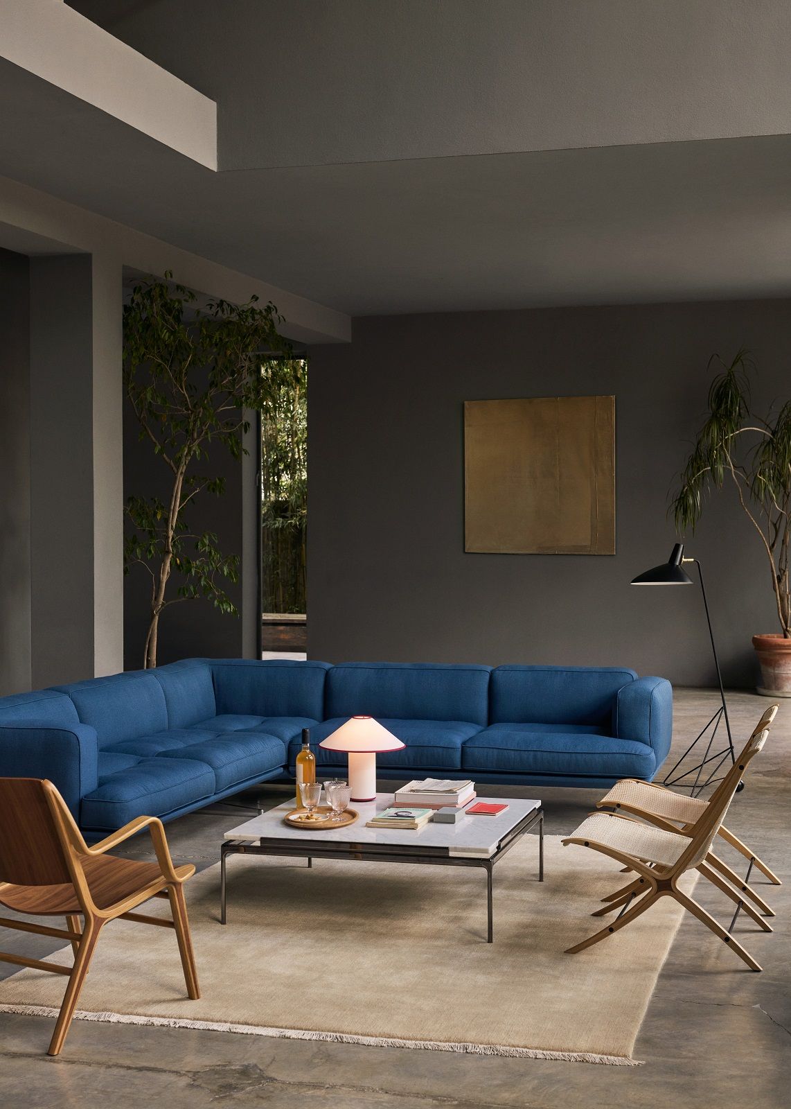 Beiger The Moor AP19 Teppich von AndTradition in einem modernen Wohnzimmer mit blauem Sofa.