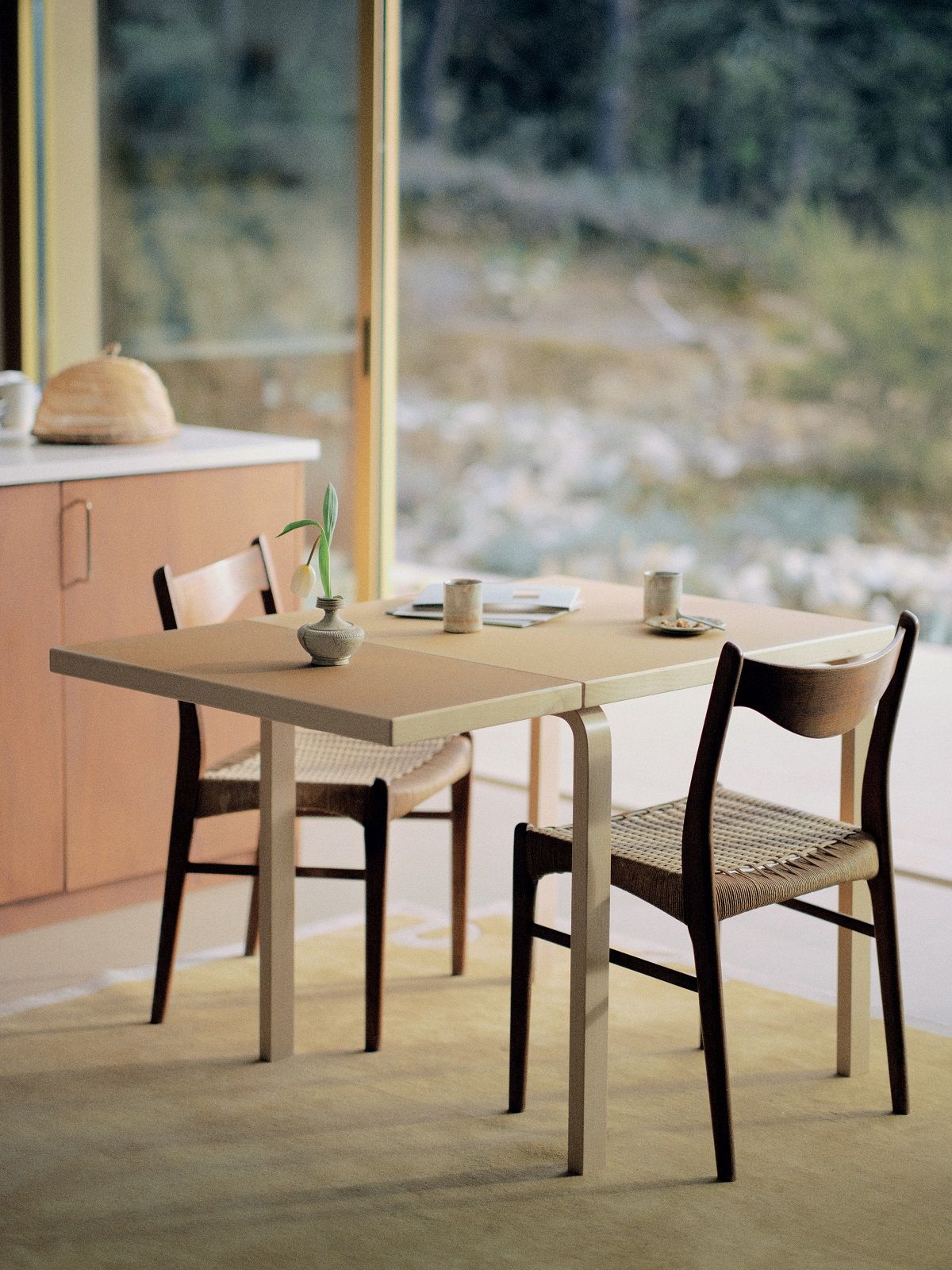 Aalto Klapptisch von Artek mit zwei Stühlen in einem hellen Raum.