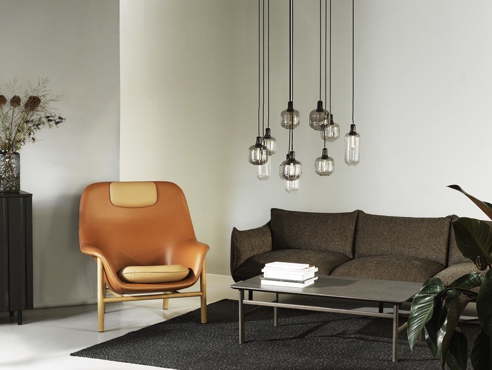 Brauner Normann Copenhagen Drape Lounge-Sessel Hoch mit Kopfstütze in modernem Wohnzimmer.