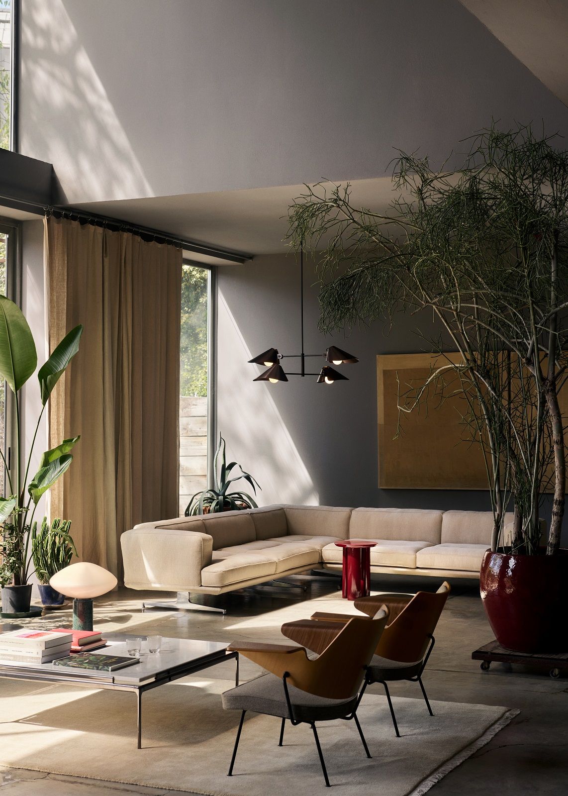 Beige The Moor Teppich von AndTradition in einem modern eingerichteten Wohnzimmer mit Sofa und Pflanzen.