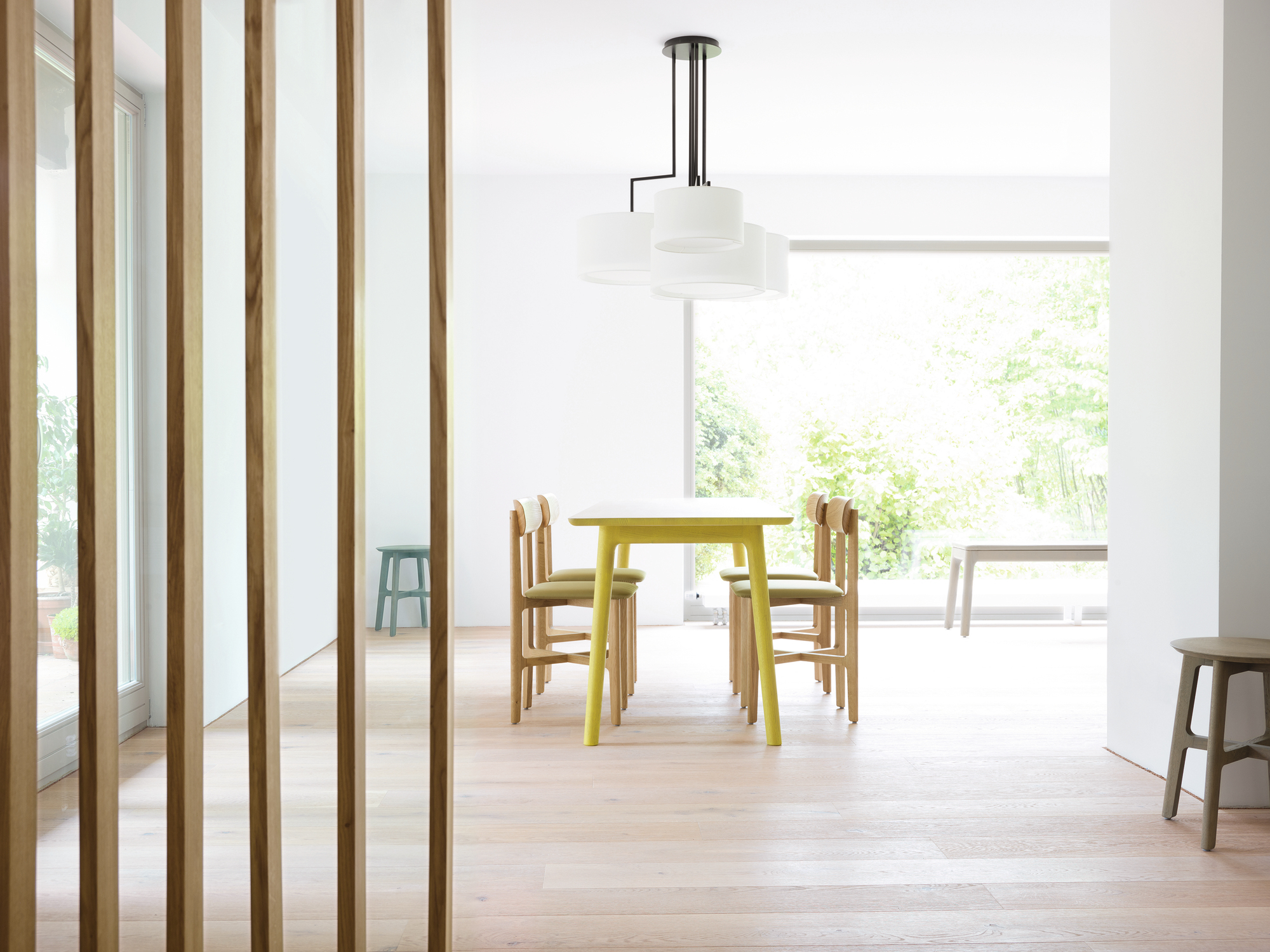Esszimmer mit 1.3 Chair Holzstühlen von Zeitraum und gelbem Esstisch unter moderner Lampe.