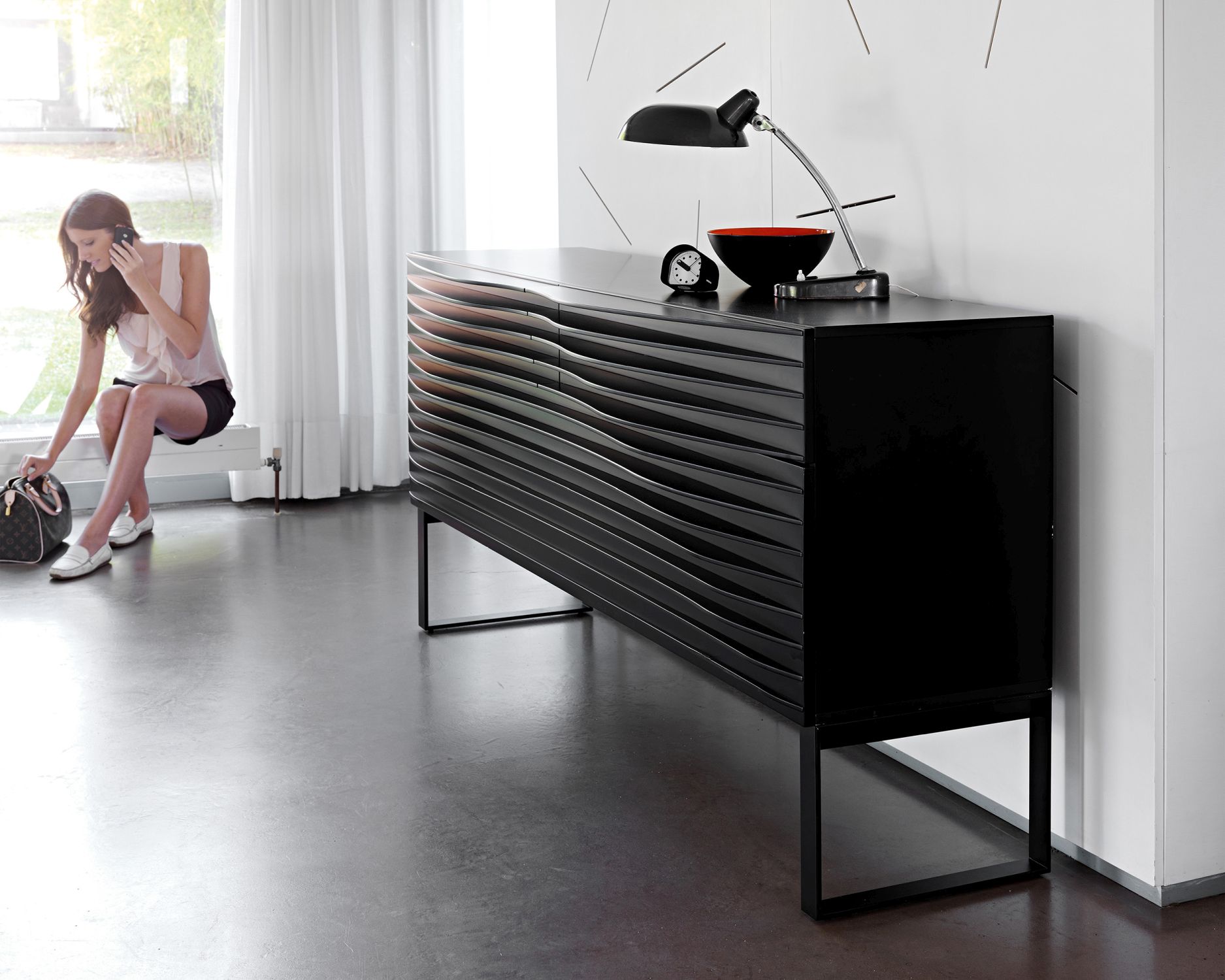 Schwarze Tide Anrichte von Casamania Horm mit minimalistischem Design und schwarzem Gestell im modernen Wohnzimmer.