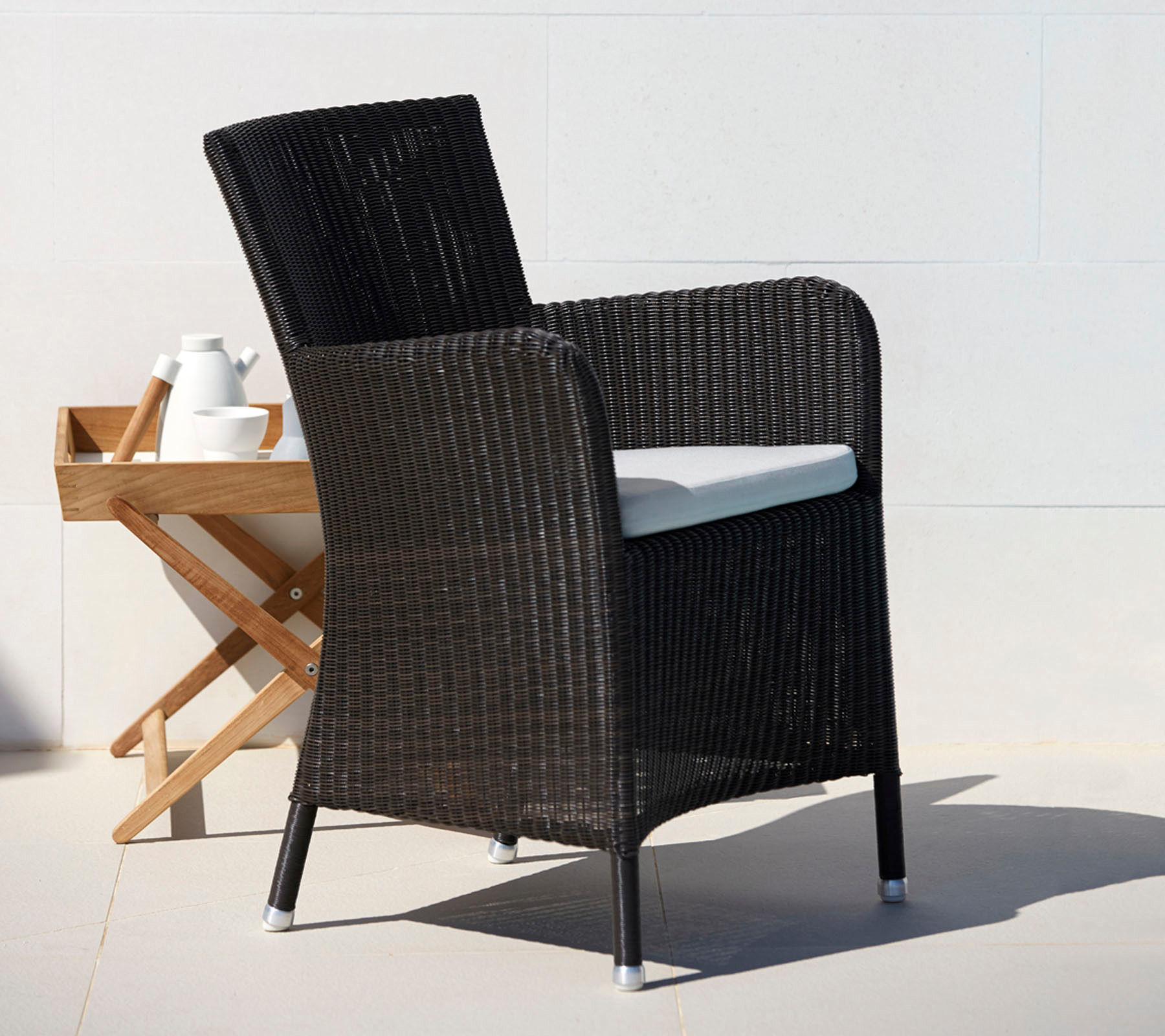 Hampsted Cane-Line Sessel: Schwarzer Rattansessel mit weißem Sitzkissen für Garten und Terrasse.
