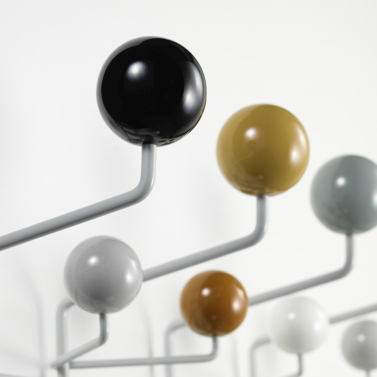 Detailaufnahme der Eames Hang it all Garderobe von Vitra in neutralen Farben mit bunten Holzkugeln.