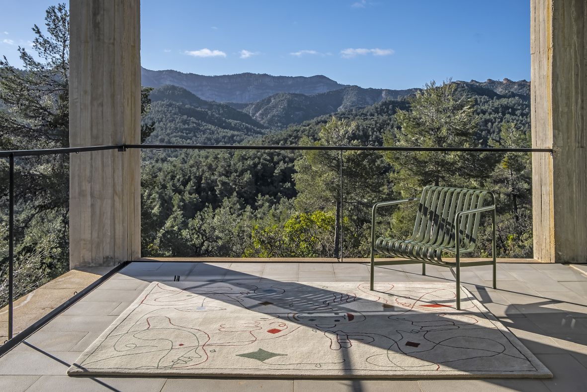 Nanimarquina Teppich Silhouette Outdoor auf Terrasse mit Stuhl und Bergblick. Design Teppich für Außen.