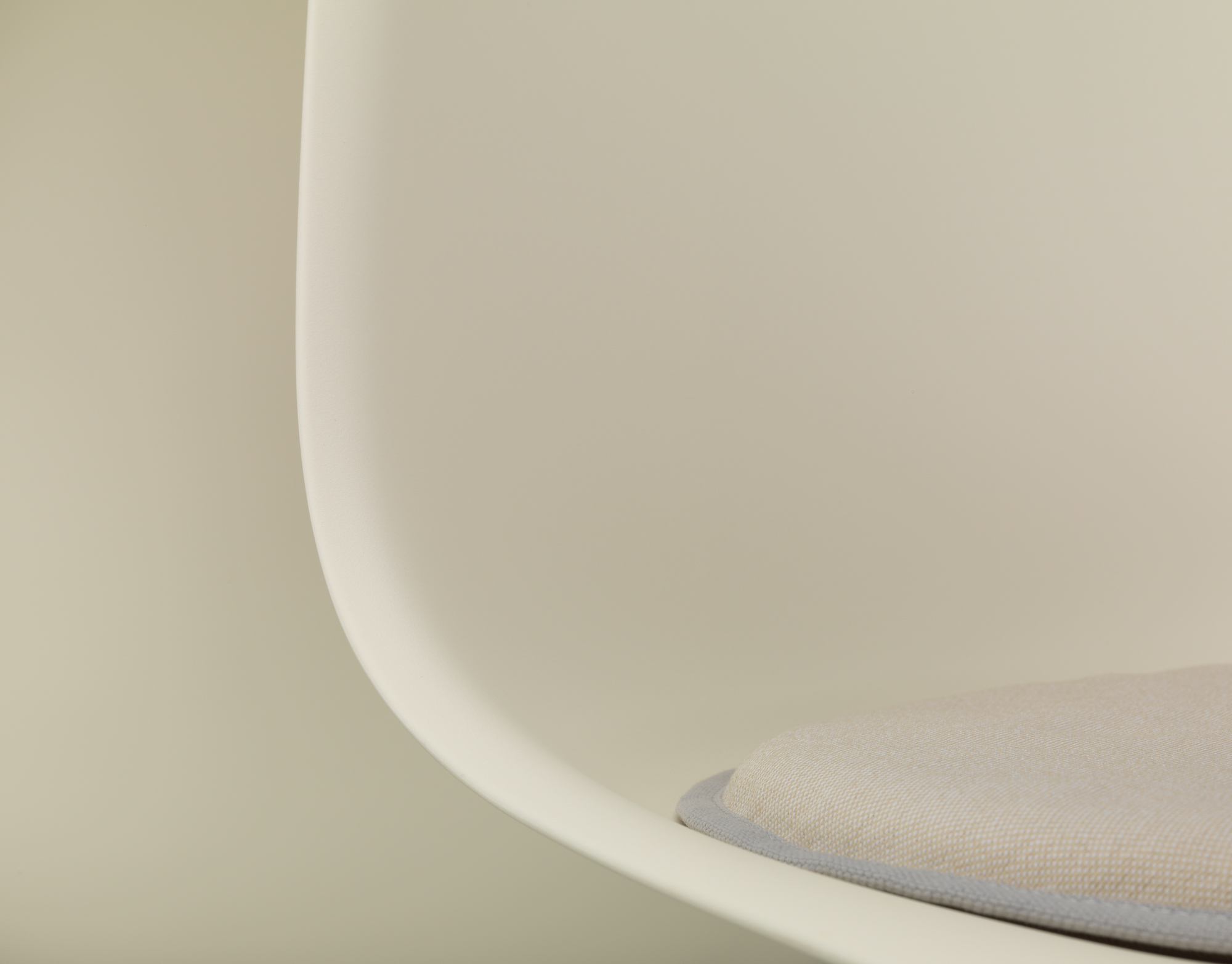 Detailaufnahme: Vitra Seat Dot Sitzkissen in Beige und Grau auf einem Stuhl.