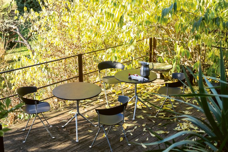 Magis Officina Stühle aus Polypropylen mit Tischen auf einer Holzterrasse im Freien.