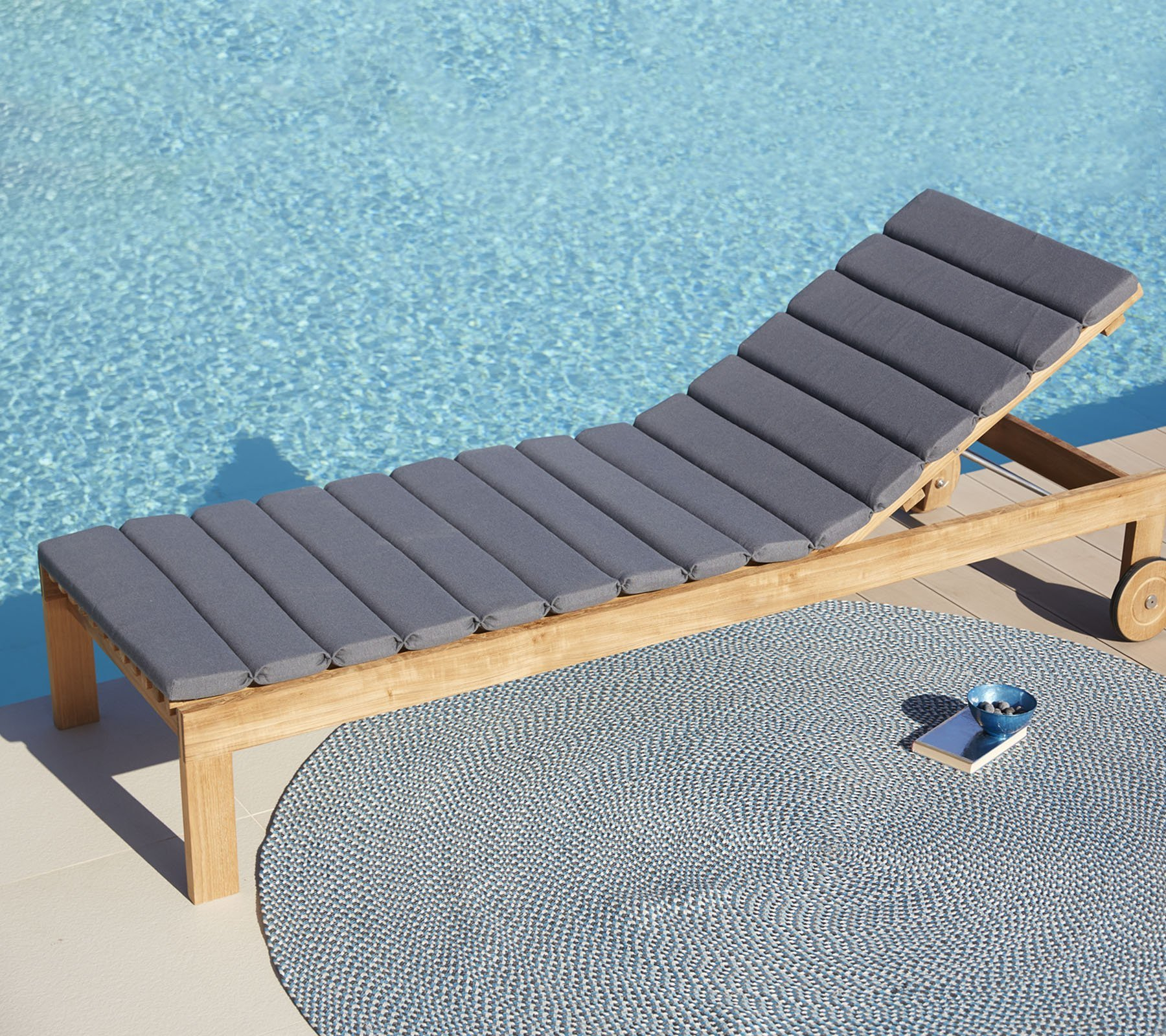 Cane-Line Amaze Sonnenliege aus Teakholz mit grauen Polstern am Pool. Outdoor Liege.