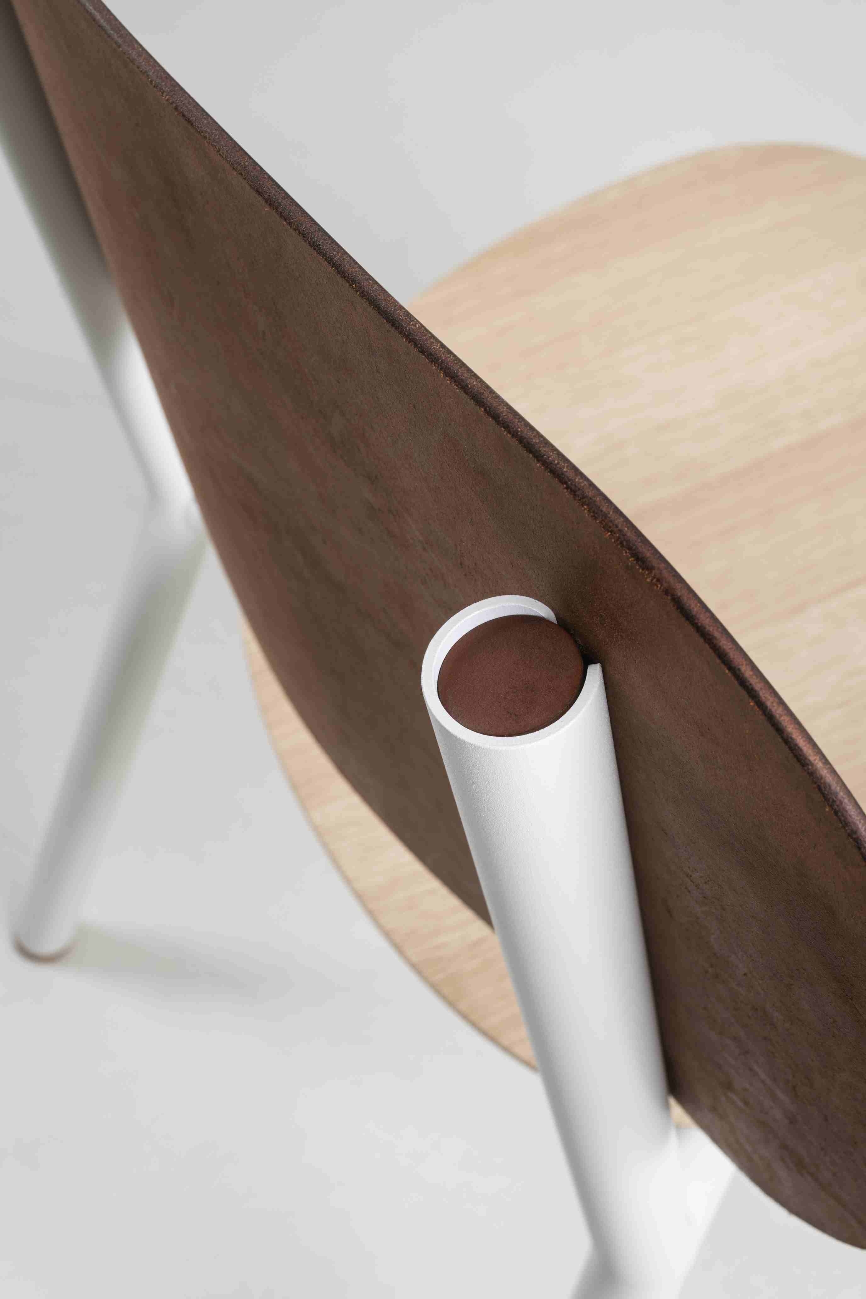Detailaufnahme des Emil Stuhls: Holzlehne, helle Sitzfläche und weiße Beine. Designstuhl für Esszimmer.