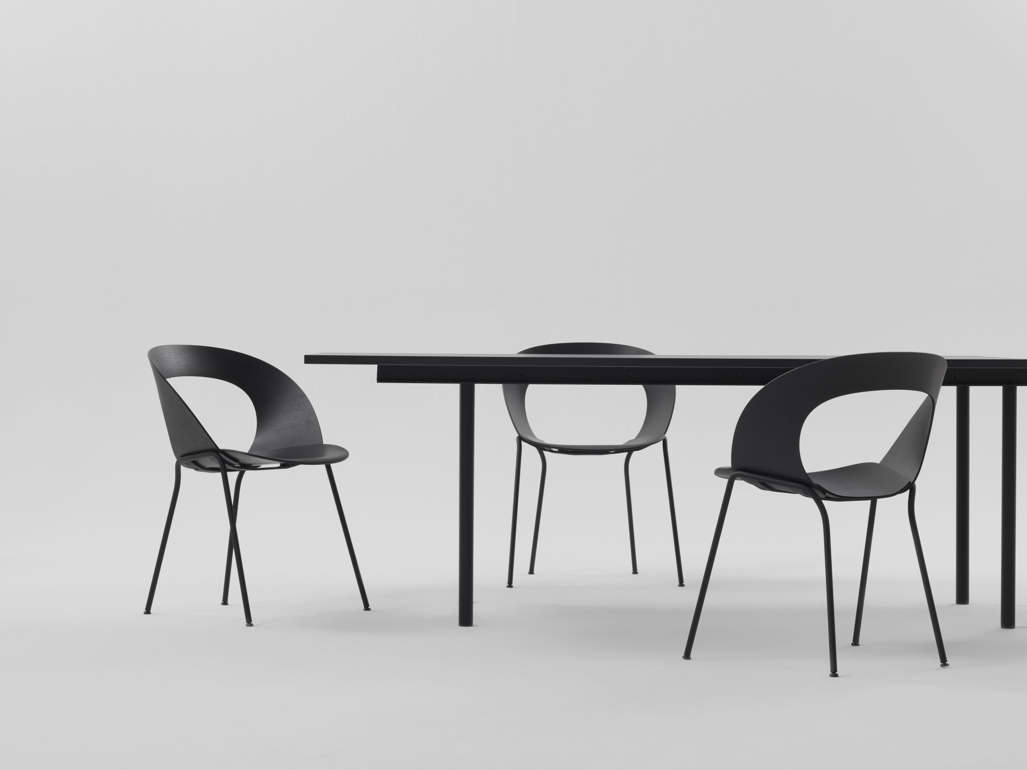 Schwarze Mudra Stühle von Brunner um einen Esstisch, minimalistisches Design für Esszimmer und Büro.