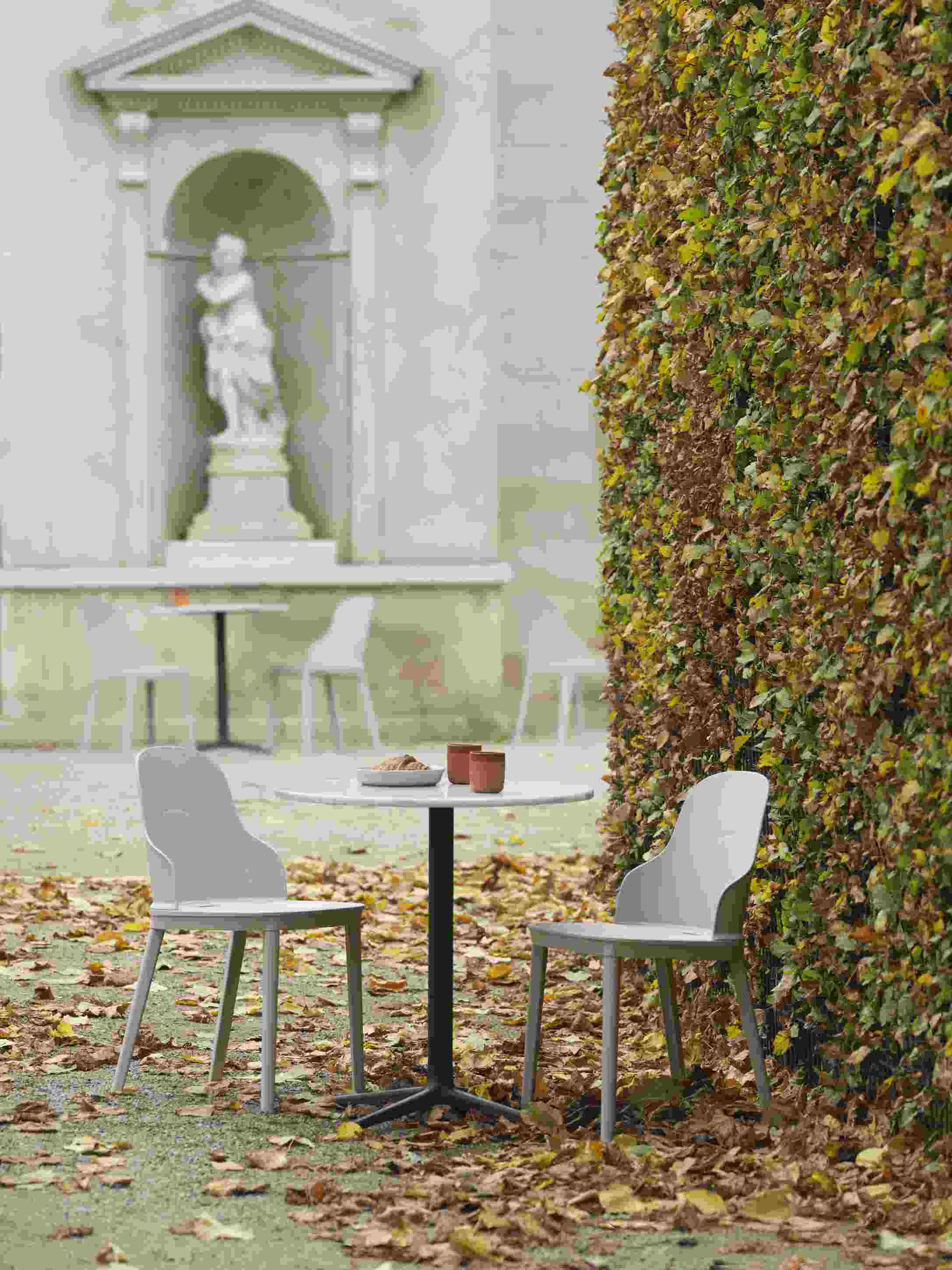Allez Chair PP Stuhl von Normann Copenhagen in Grau, mit Tisch und Herbstlaub im Garten.