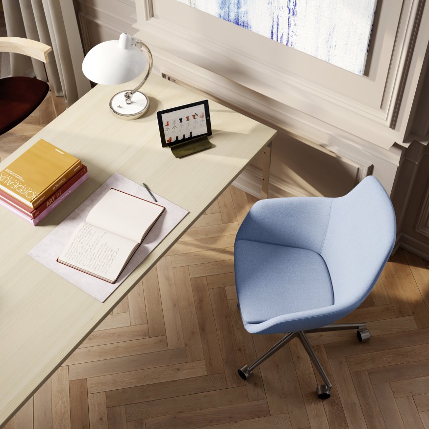 Draufsicht auf einen hellen PK51 Esstisch von Fritz Hansen mit Büchern, Tablet und blauem Bürostuhl.