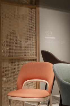 Nahaufnahme eines orangefarbenen Thonet 520 P Polsterstuhls mit hellen Holzrahmen, Teil einer Stuhlkollektion.