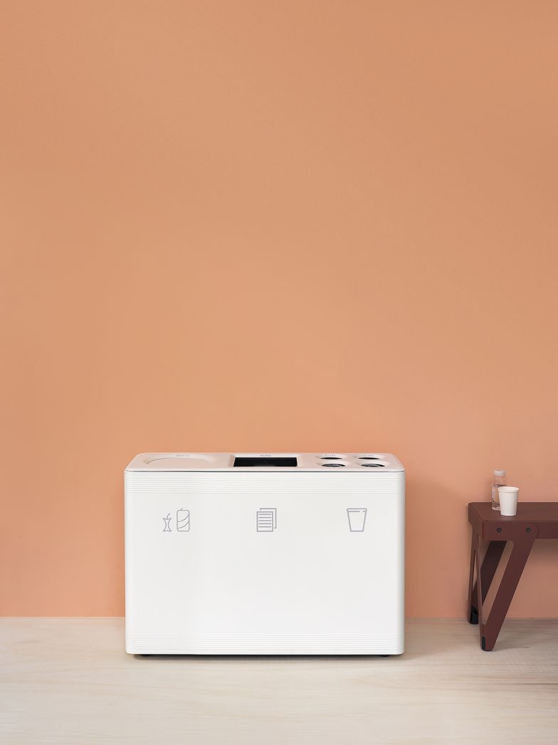 Weißes Ditch 3 Abfalltrennsystem Functionals mit Symbolen für Bio, Papier und Wertstoffe vor orangefarbener Wand.