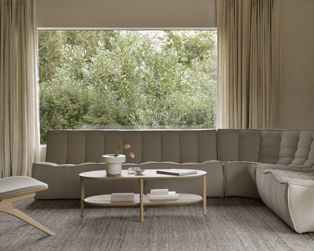 Bok Couchtisch lang von Ethnicraft aus Eiche mit einem Regal in einem Wohnzimmer.