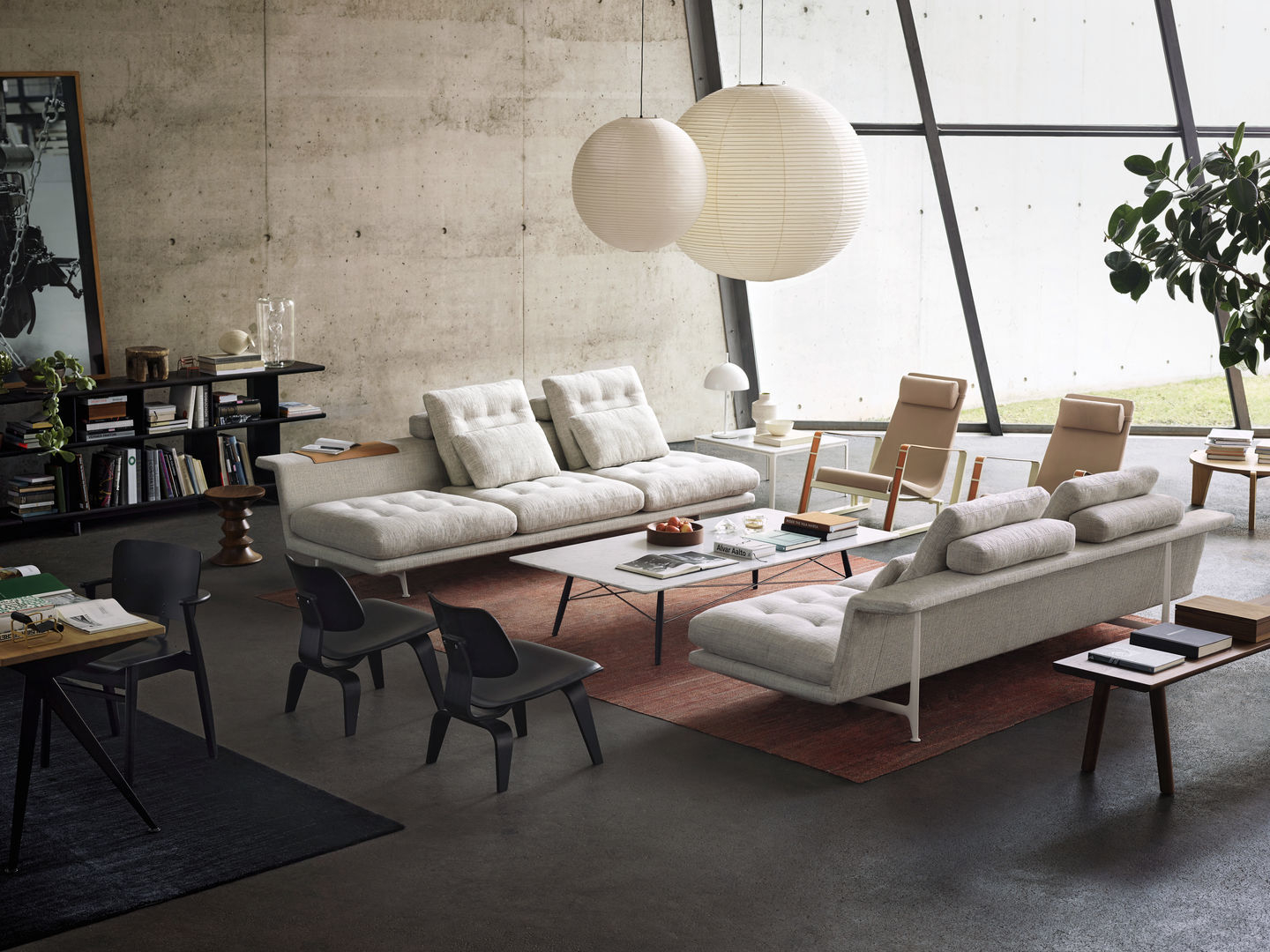 Helle Wohnzimmer-Szene mit zwei Akari Pendelleuchten von Vitra, Sofas, Sesseln und minimalistischem Design.