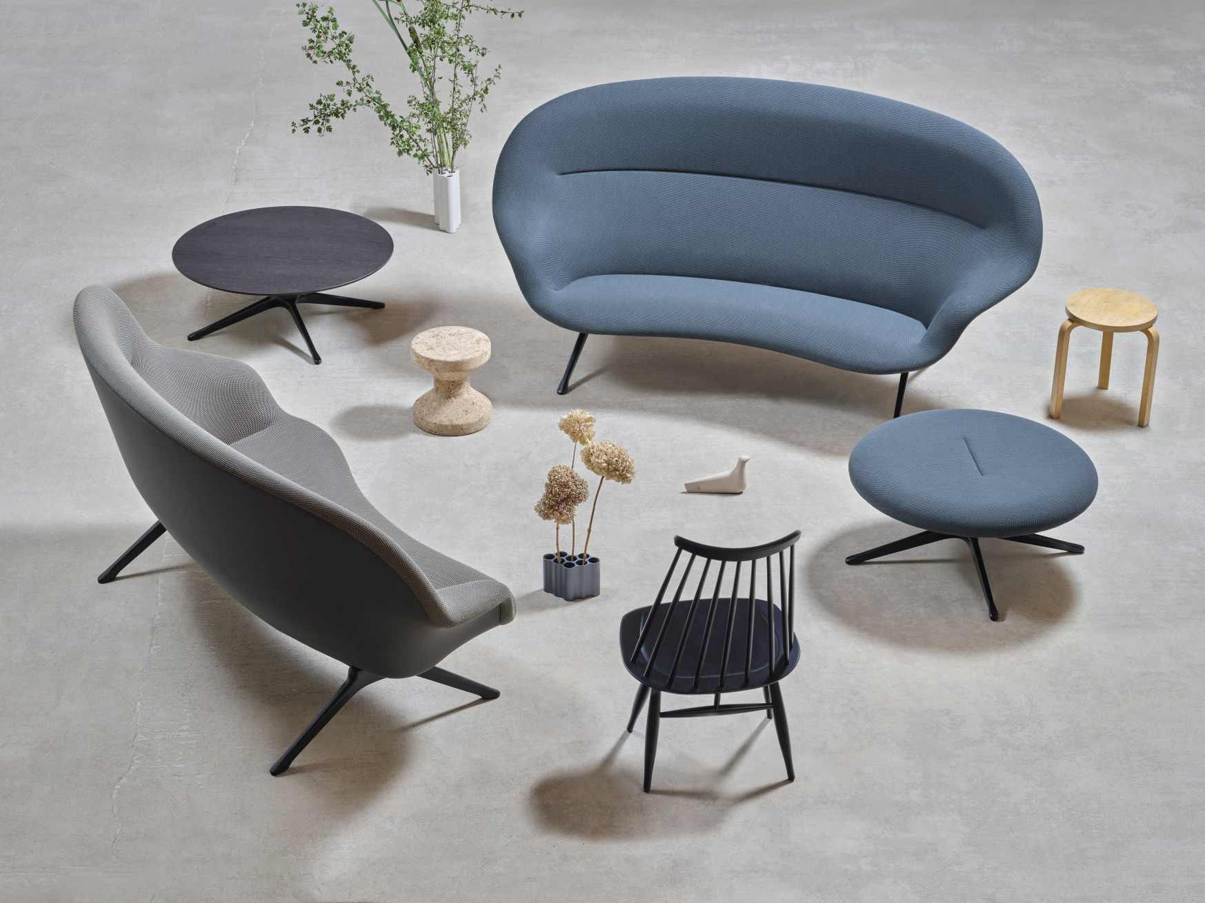 Blaues Abalon Sofa von Vitra mit passendem Sessel, Hocker und Tisch in modernem Ambiente.