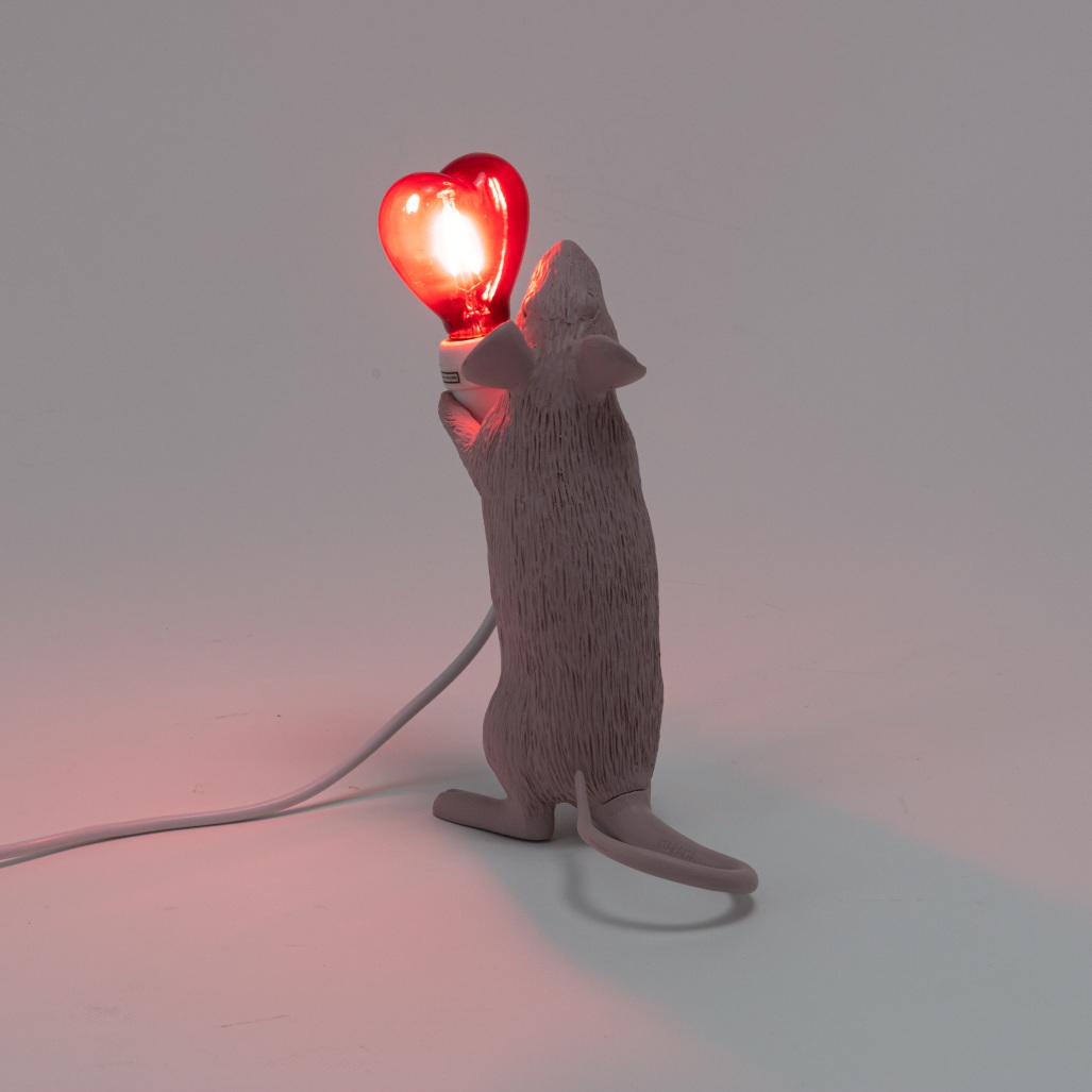 Seletti Mouse Lamp Step Love Edition: Graue Maus hält leuchtende, rote Herz-Glühbirne als Tischleuchte.