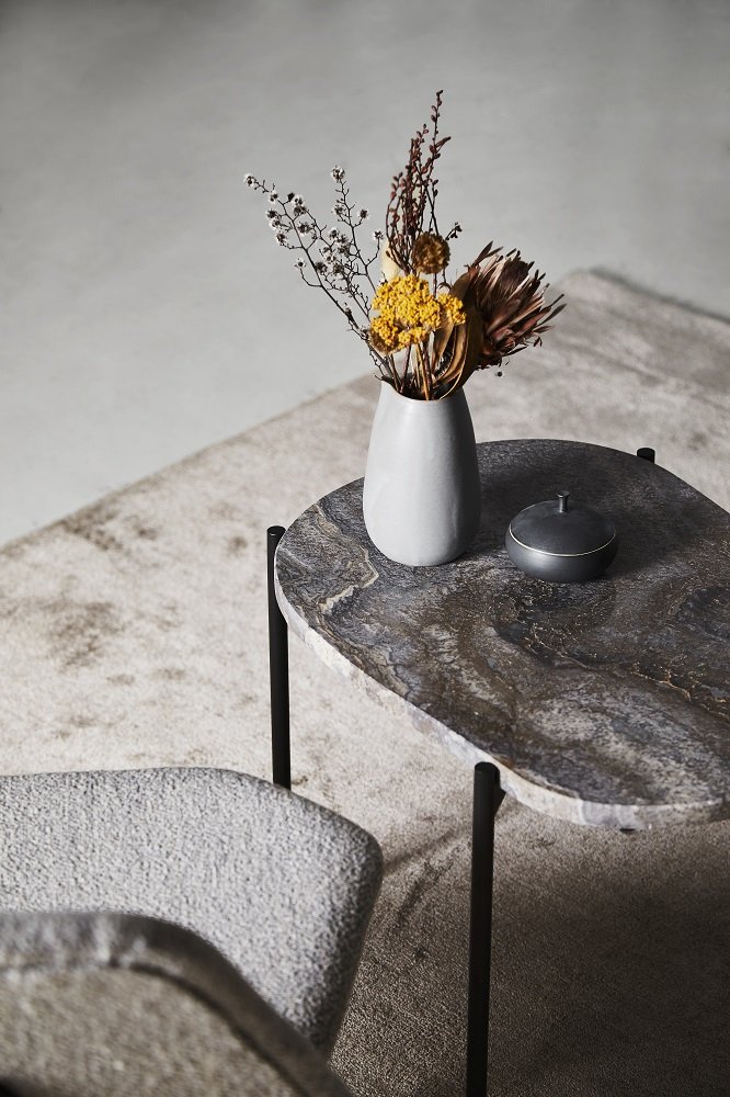 La Terra Couchtisch von Woud, Medium, Grau melange mit Blumen und Dose auf Teppich.