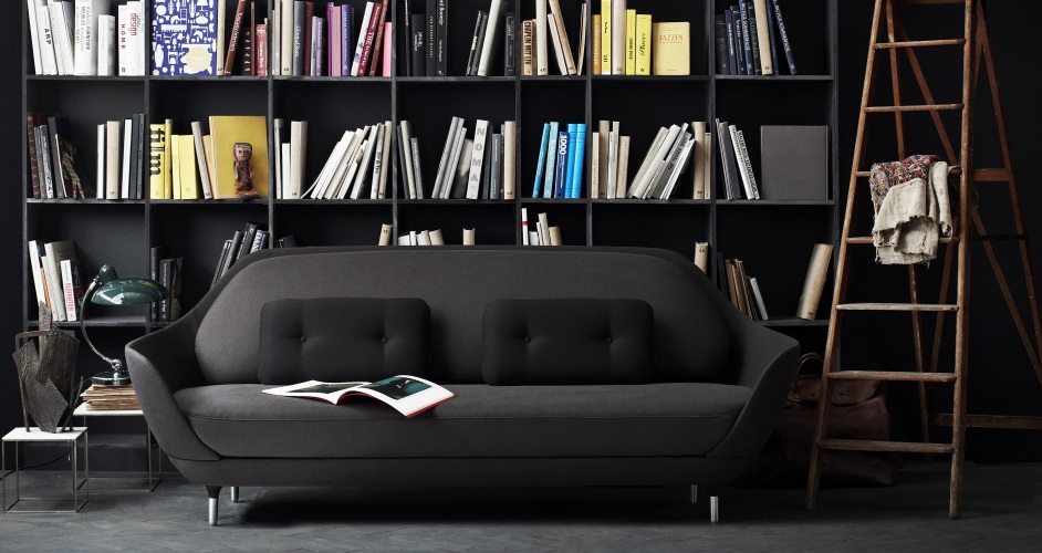Graues Favn Sofa von Fritz Hansen mit schwarzen Kissen vor einem Bücherregal und einer Leiter.