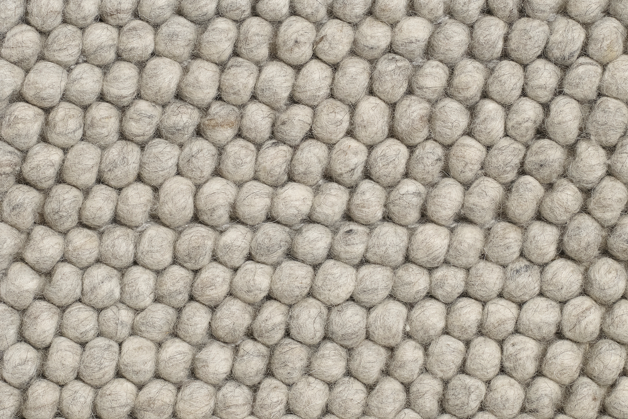 Detailaufnahme des Hay Peas Teppichs, L 200 x B 140 cm, in soft grau. Wollteppich mit erbsenförmiger Struktur.