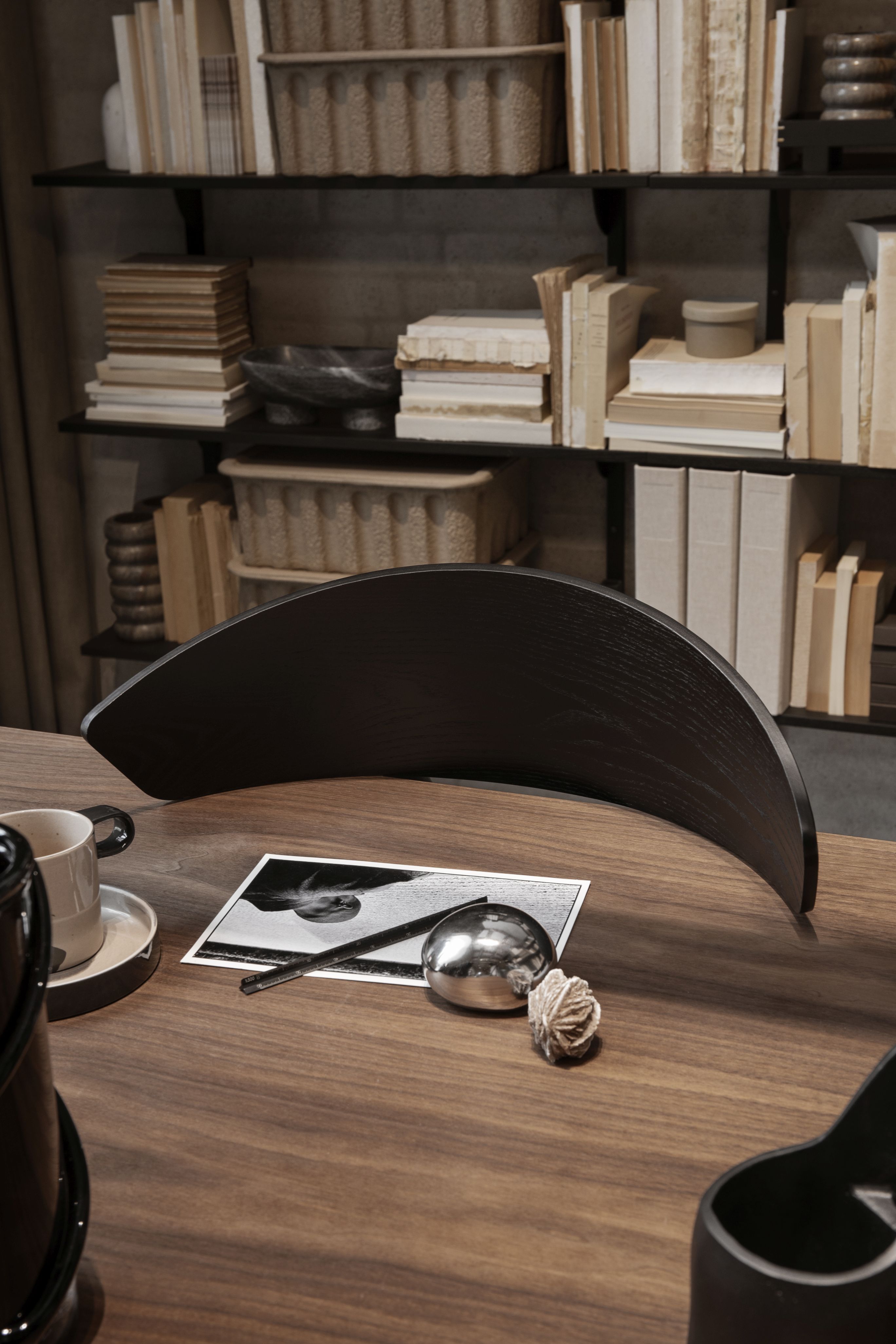 Detailaufnahme eines Herman Esszimmerstuhls von Ferm Living mit dunklem Holzgestell an einem Holztisch.