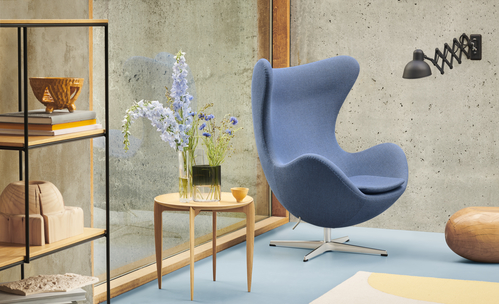 Blauer Egg Chair Sessel im modernen Wohnzimmer mit Beistelltisch und Regal. Designmöbel für stilvolles Wohnen.