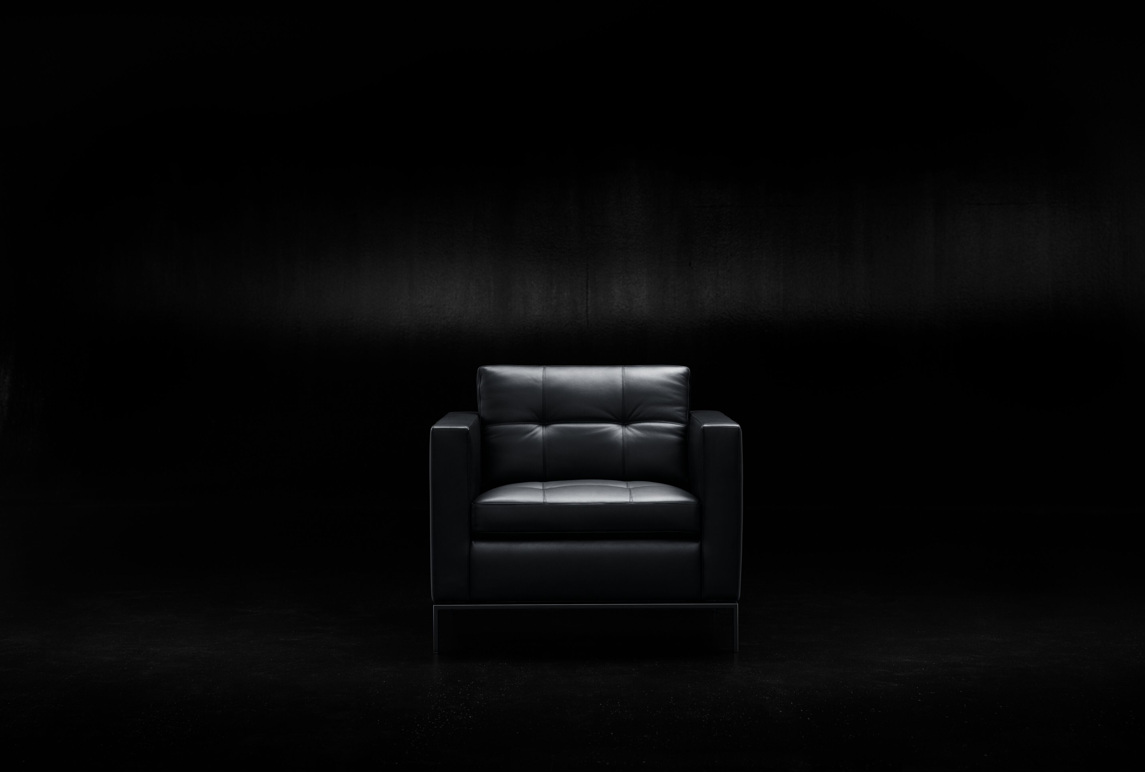 Schwarzer 502 Foster Sessel von Walter Knoll mit Lederbezug und minimalistischem Design vor dunklem Hintergrund.