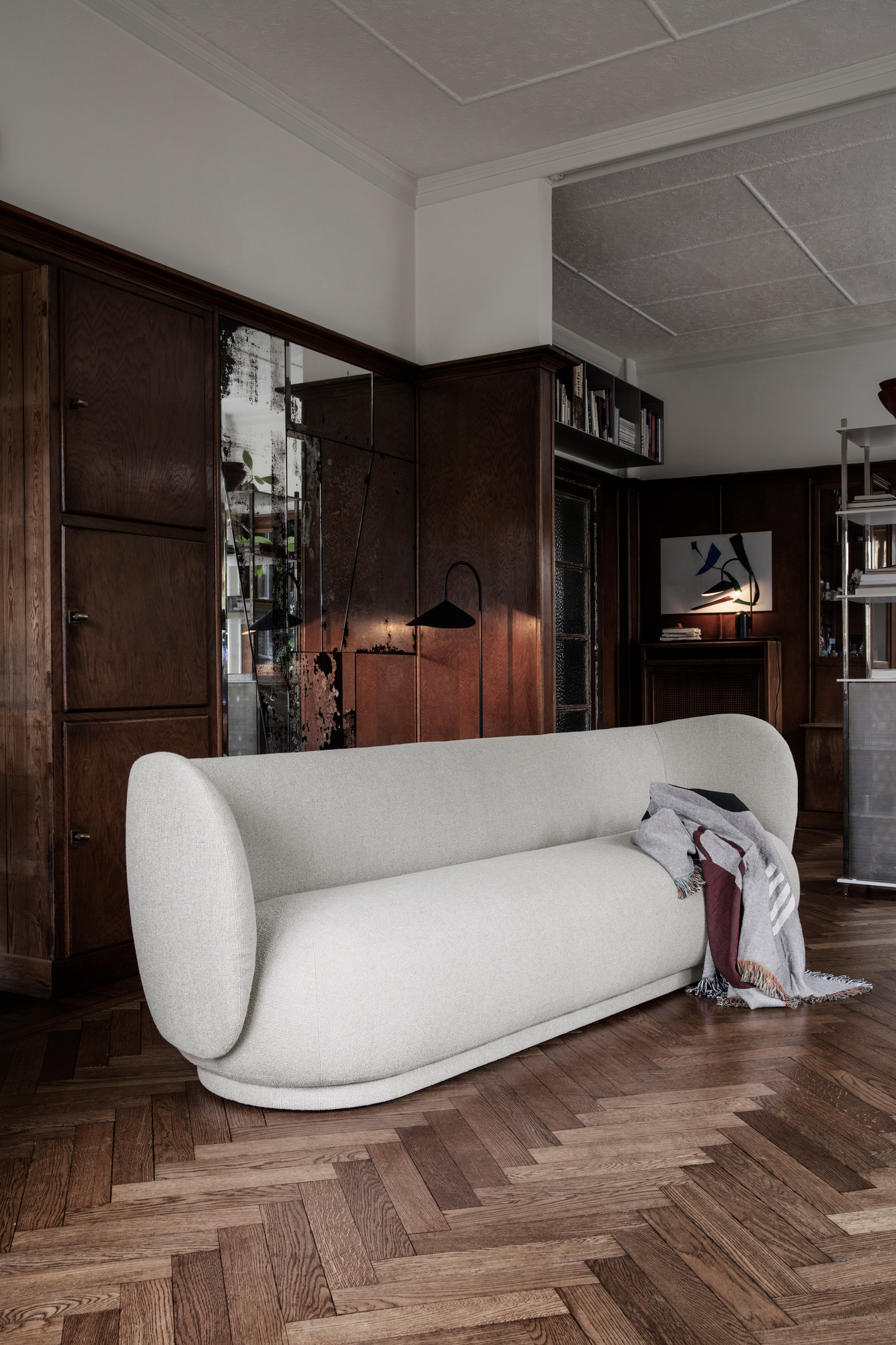Beige Rico Sofa von Ferm Living, 4-Sitzer, mit Decke auf Parkettboden in stilvollem Interieur.