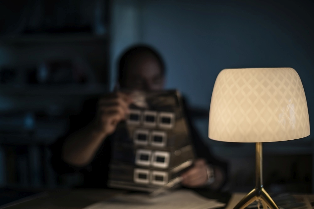 Nahaufnahme der Lumiere Tischleuchte von Foscarini mit weißem Lampenschirm und goldenem Fuß.